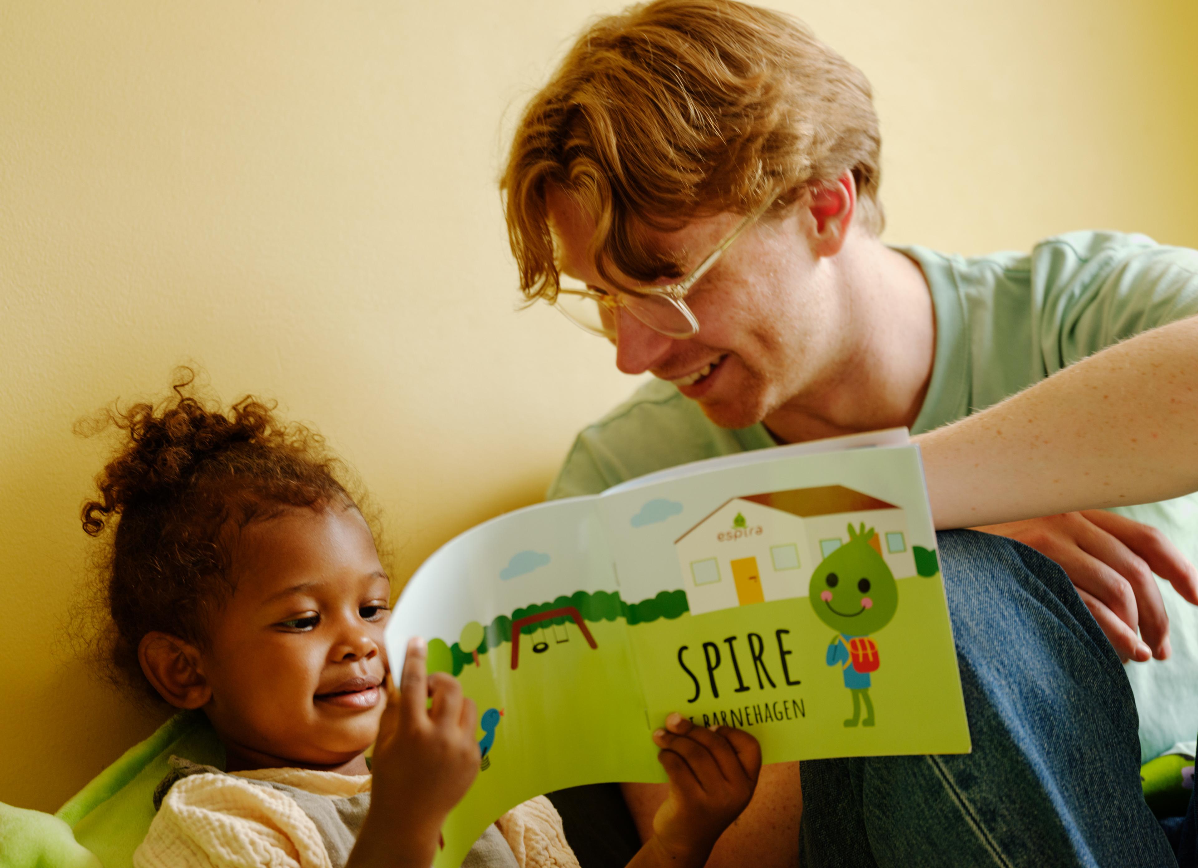 a man is reading a book to a little girl .
