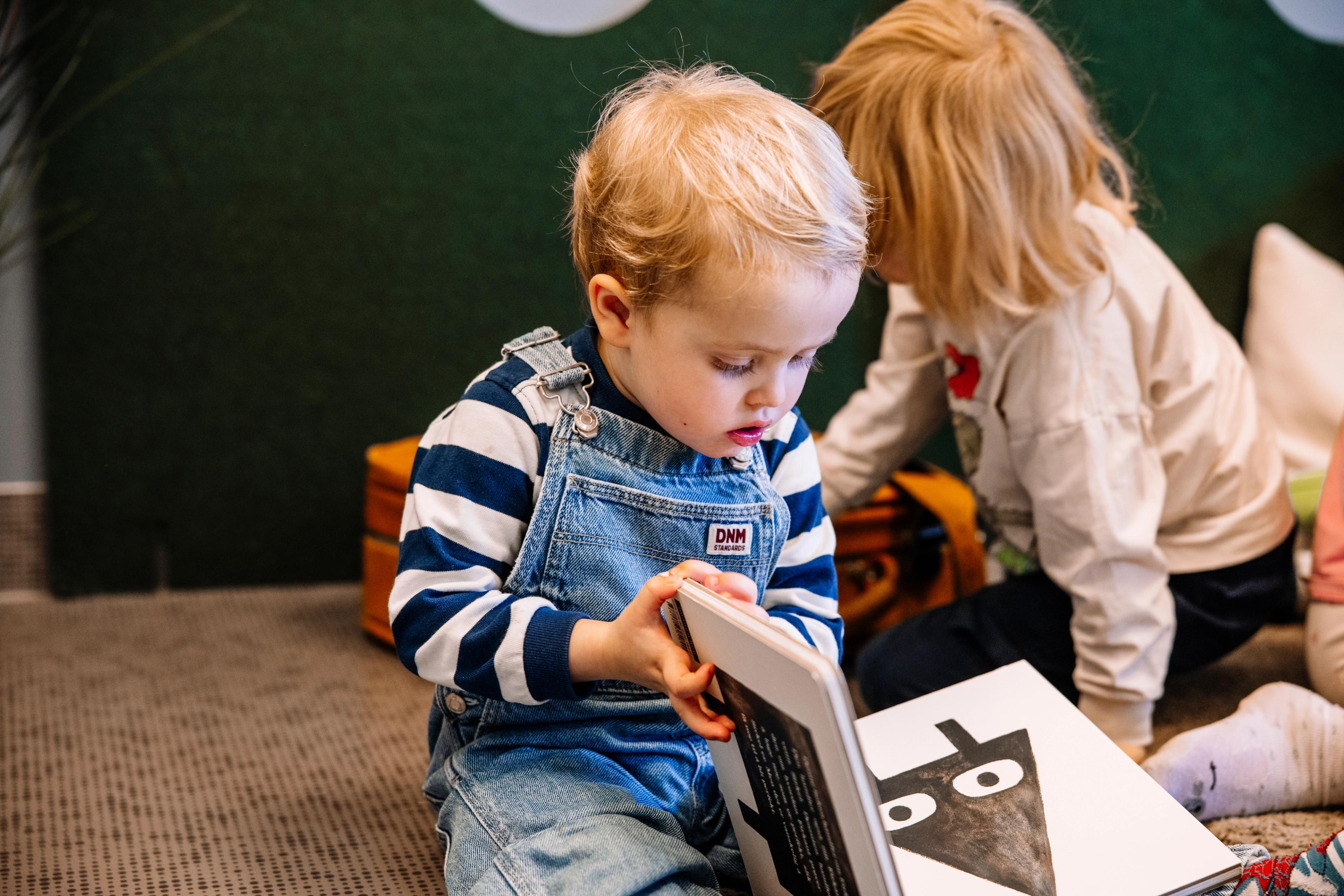 Barnehagebarn leser spennende bok