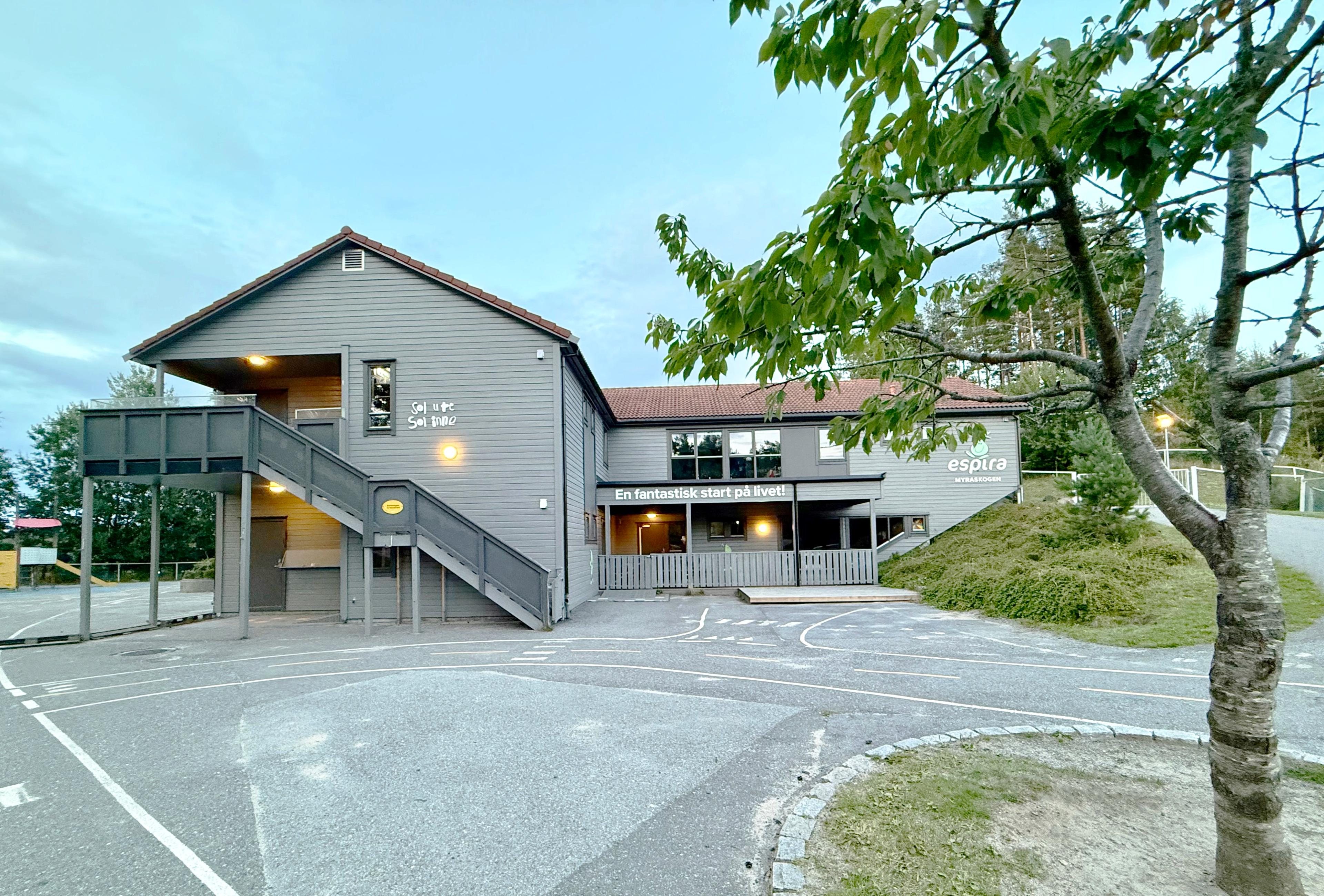 Forsiden av Espira Myraskogen barnehage med inngangsparti og uteområde.