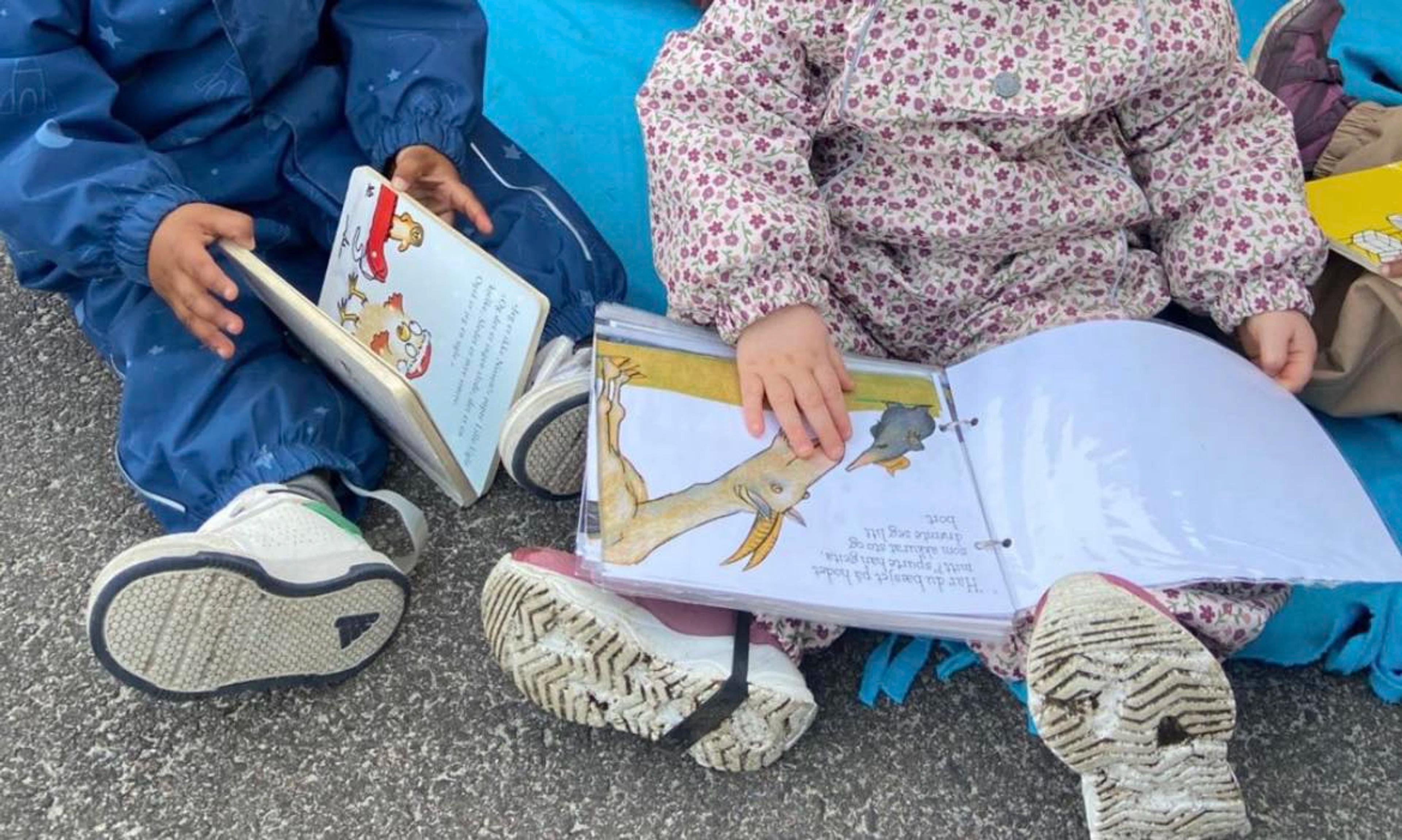 Barn som leser sammen ute i Espira Bjørgene