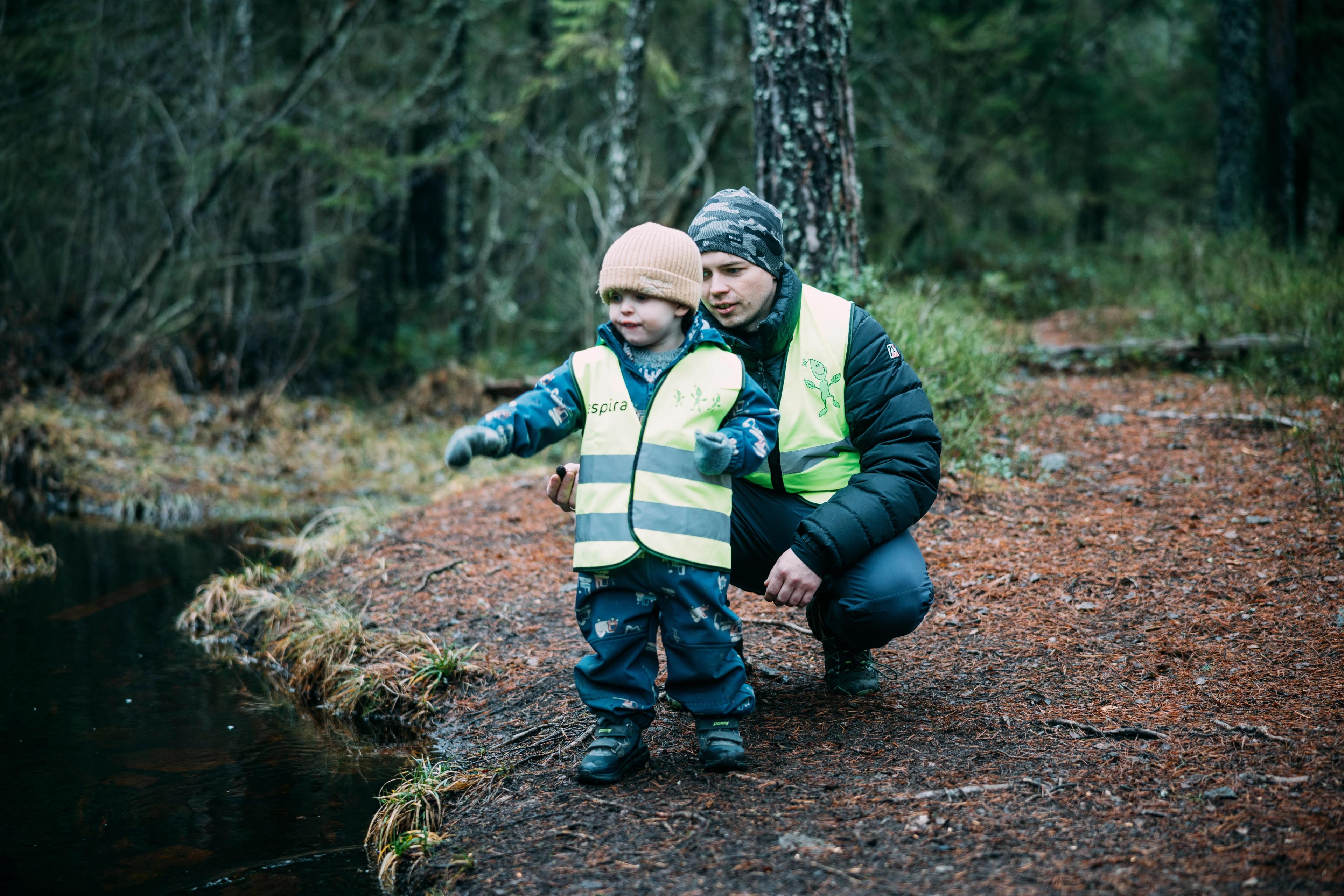Barn og ansatt i barnehagen på tur i skogen på høsten
