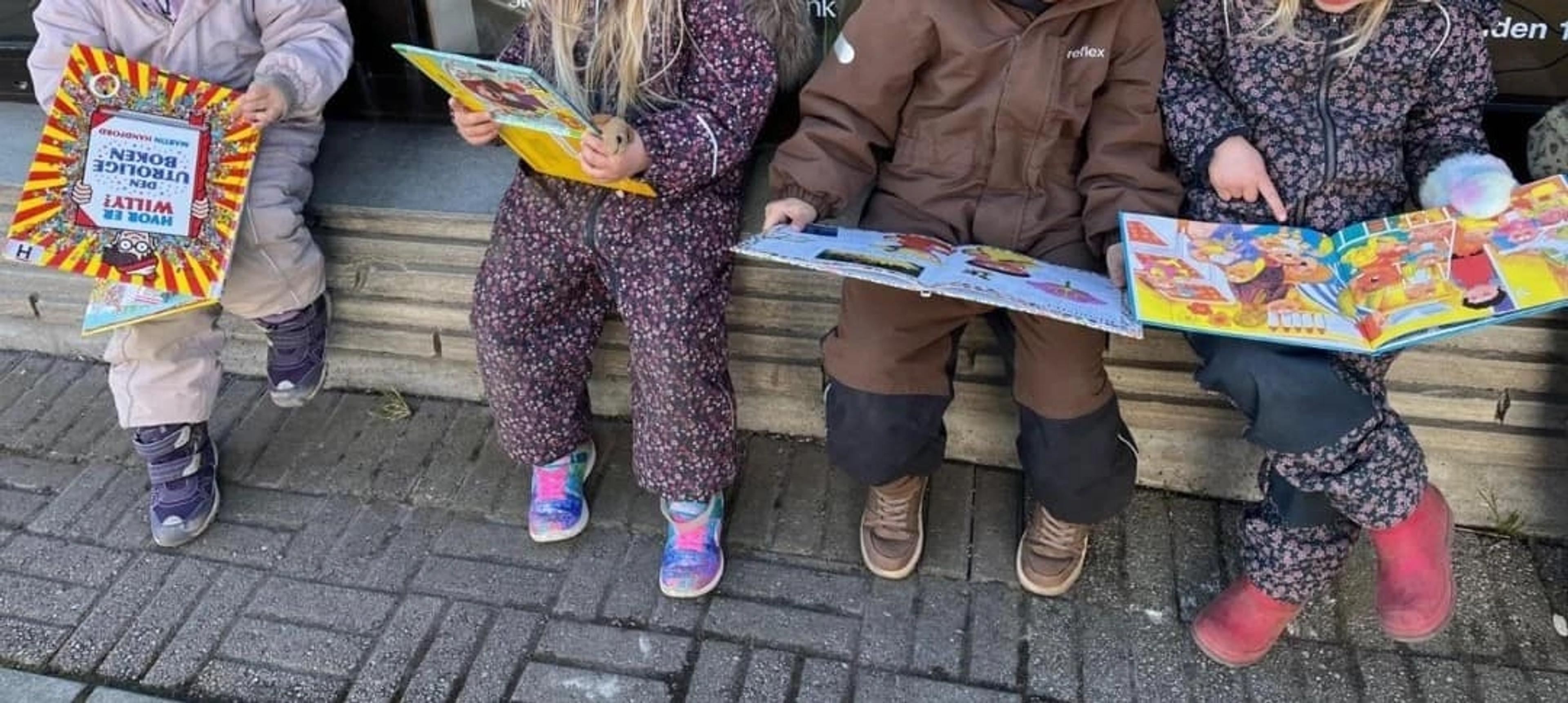 Barn som leser bøker ute i Espira Sletten