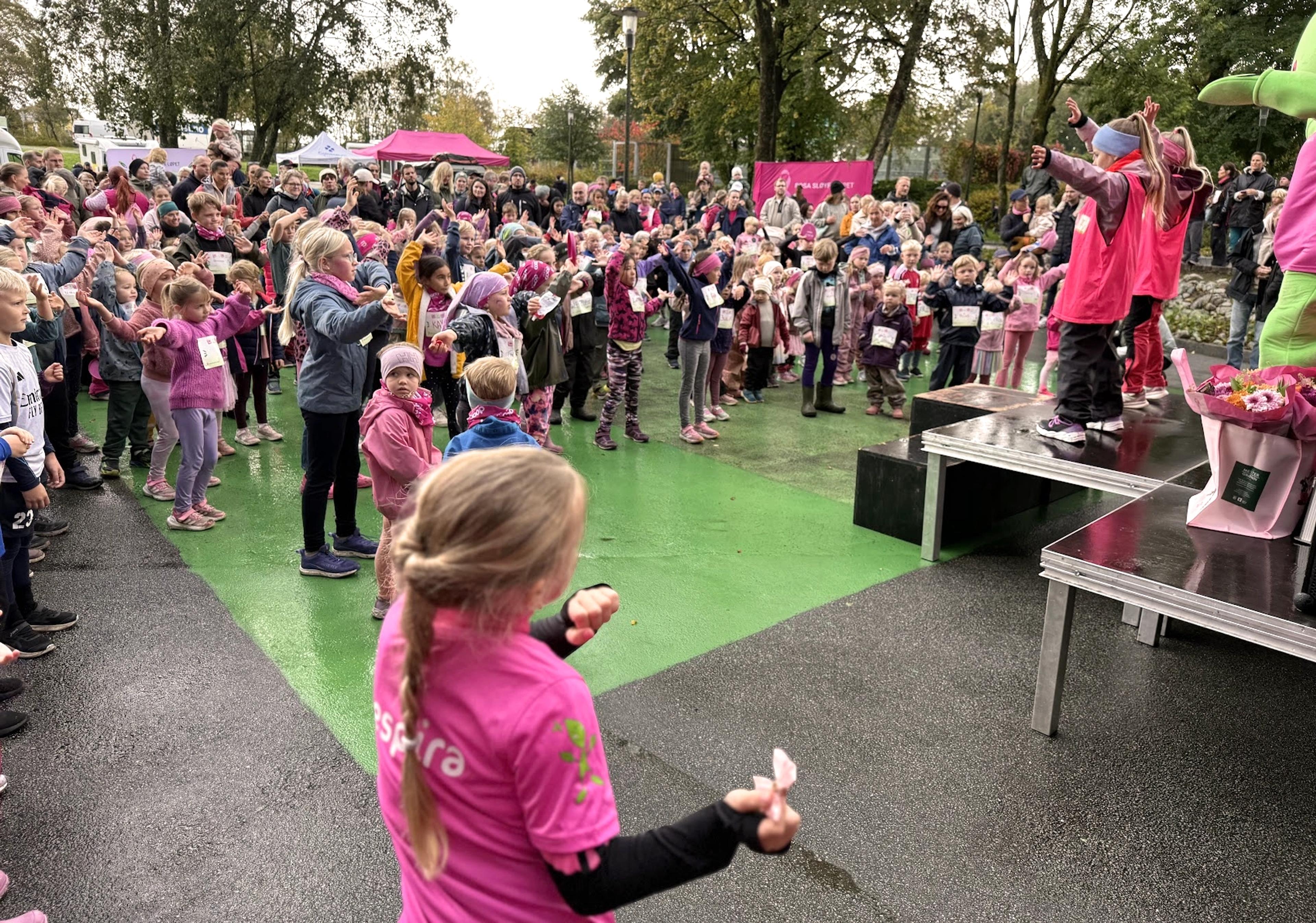 Barn som danser ute i under Rosa Sløyfe Mini løpet