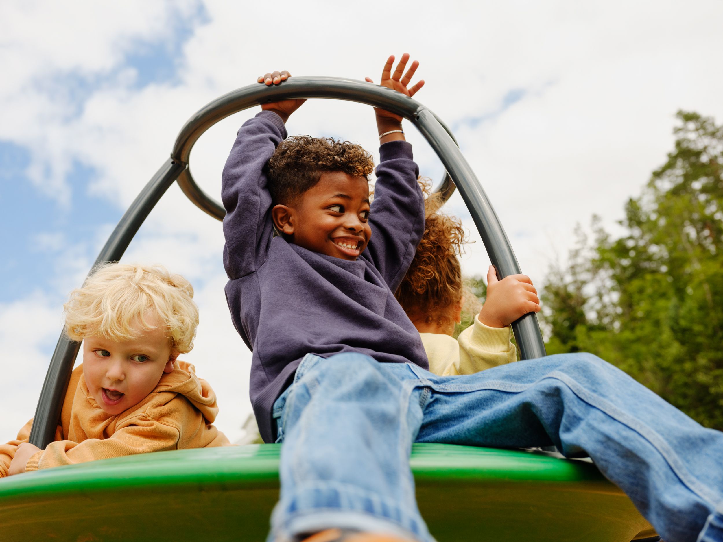 a group of children are riding a merry go round at a playground .