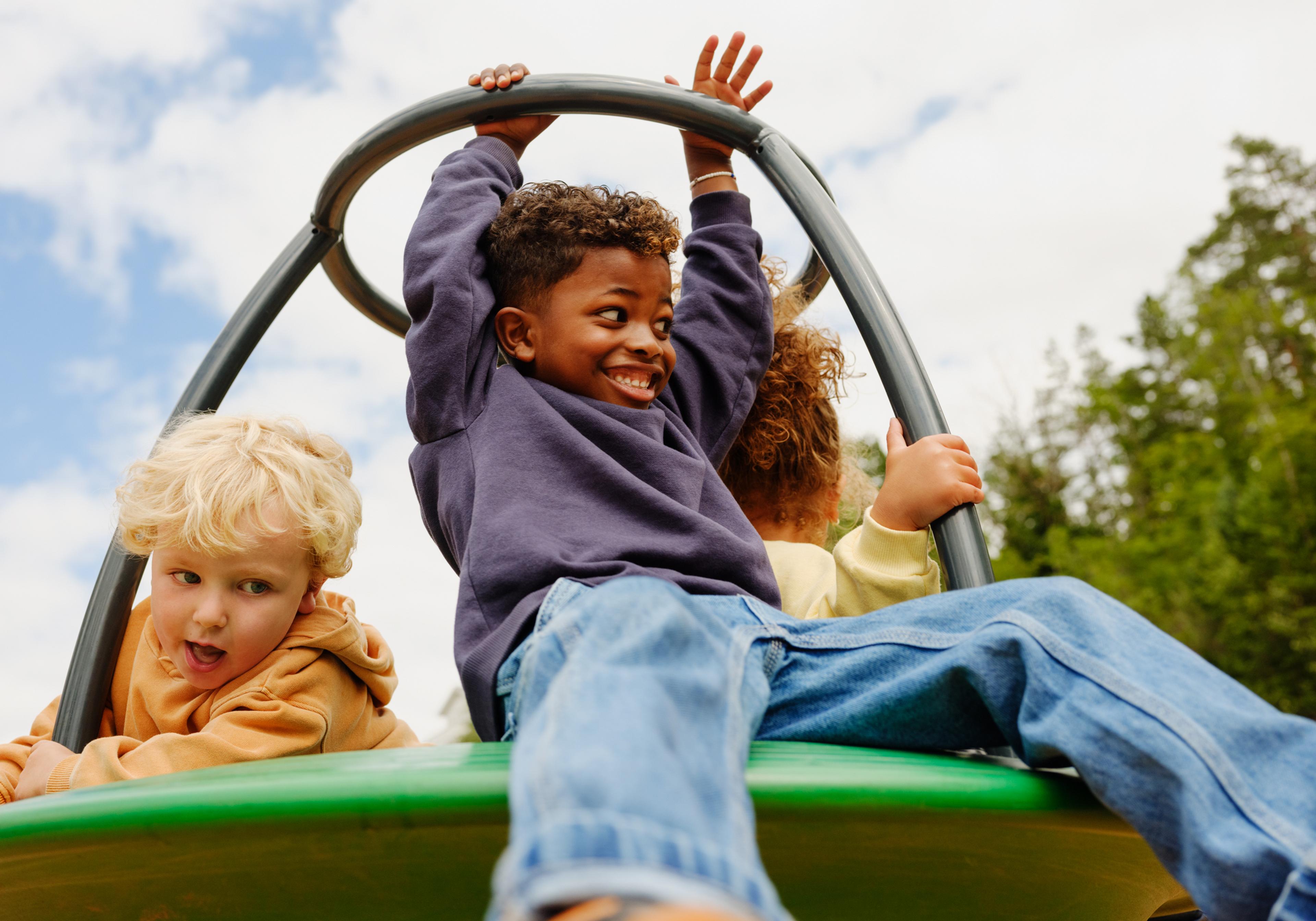 a group of children are riding a merry go round at a playground .