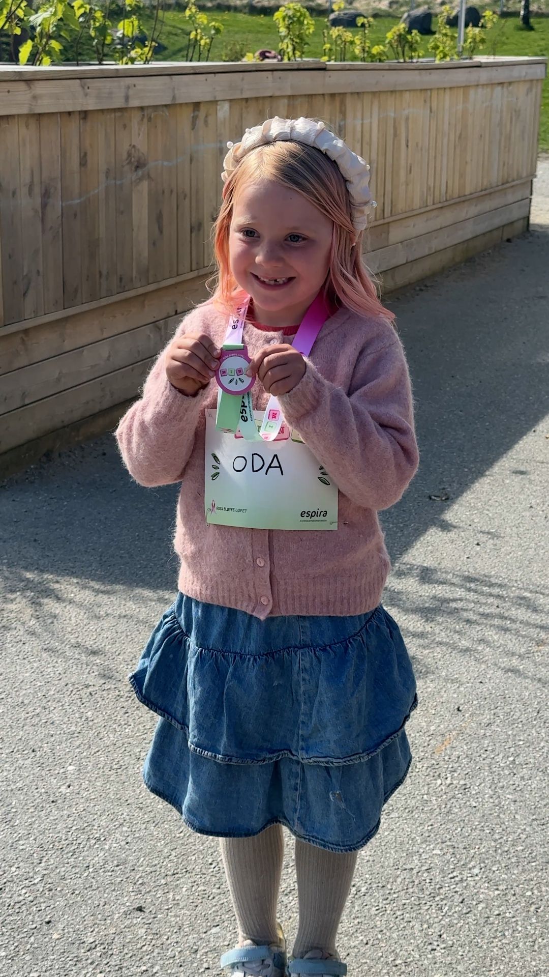 two little girls are running with one wearing a black sweatshirt that says skolespira 2022