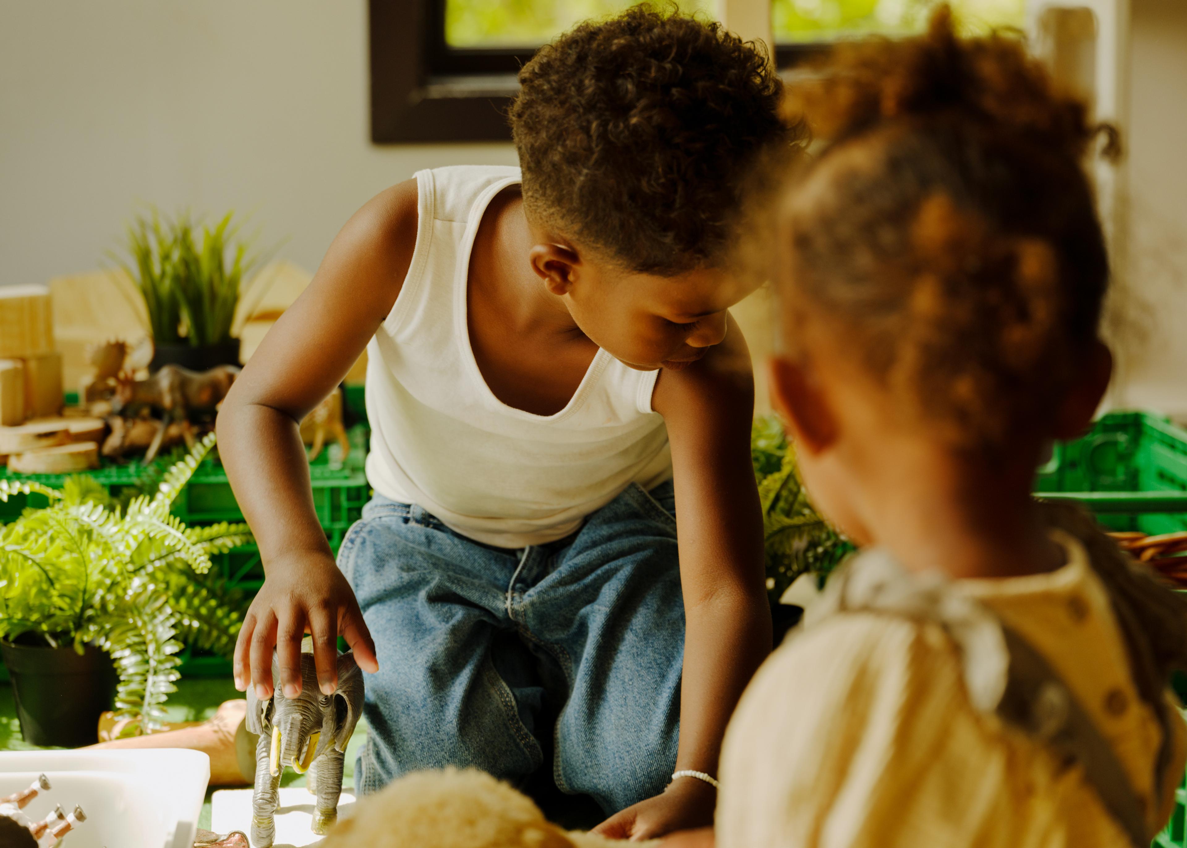 a boy and a girl are playing with toys in a kitchen .