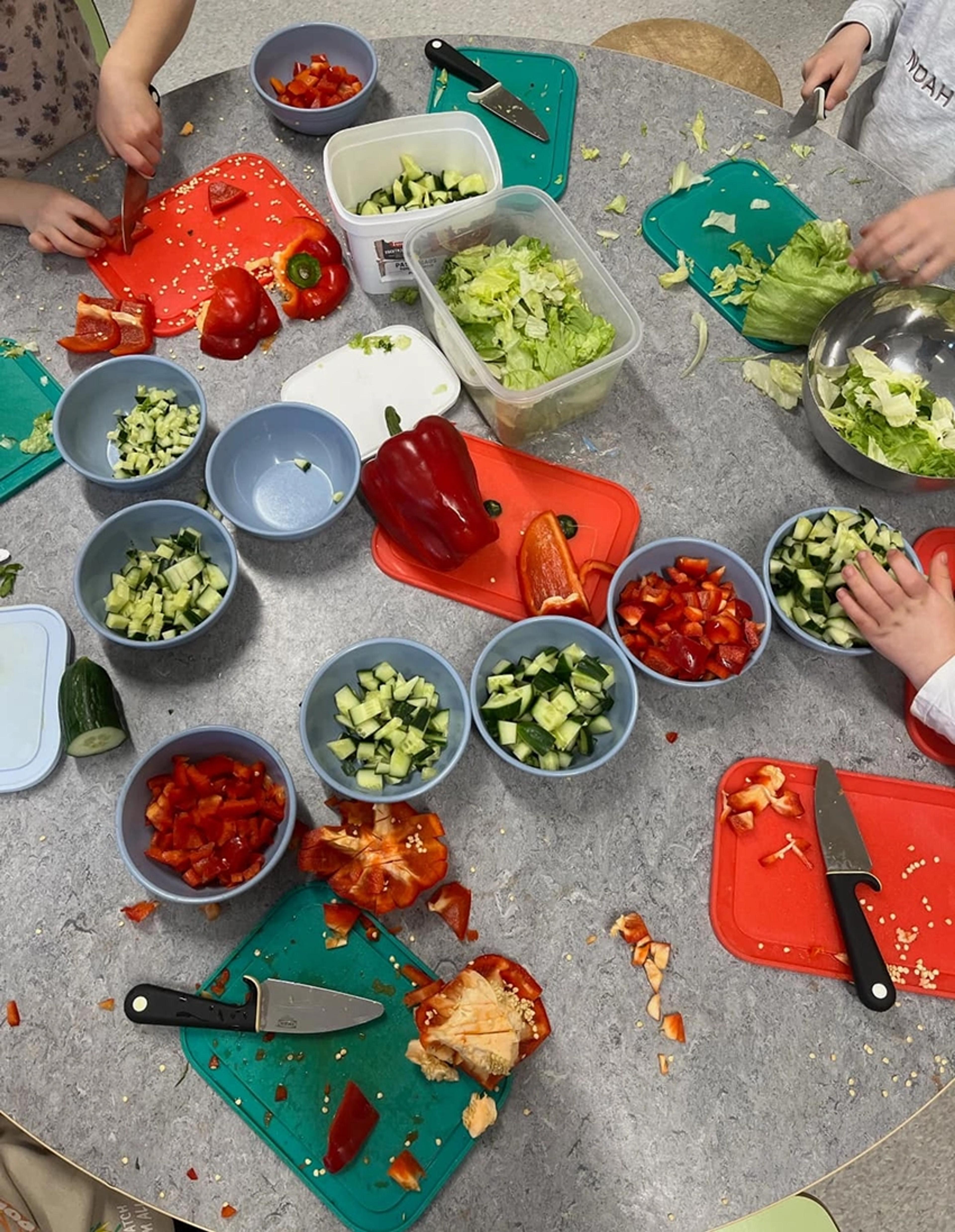 Barn som lager mat, kutter grønnsaker, i Espira Dvergsnes