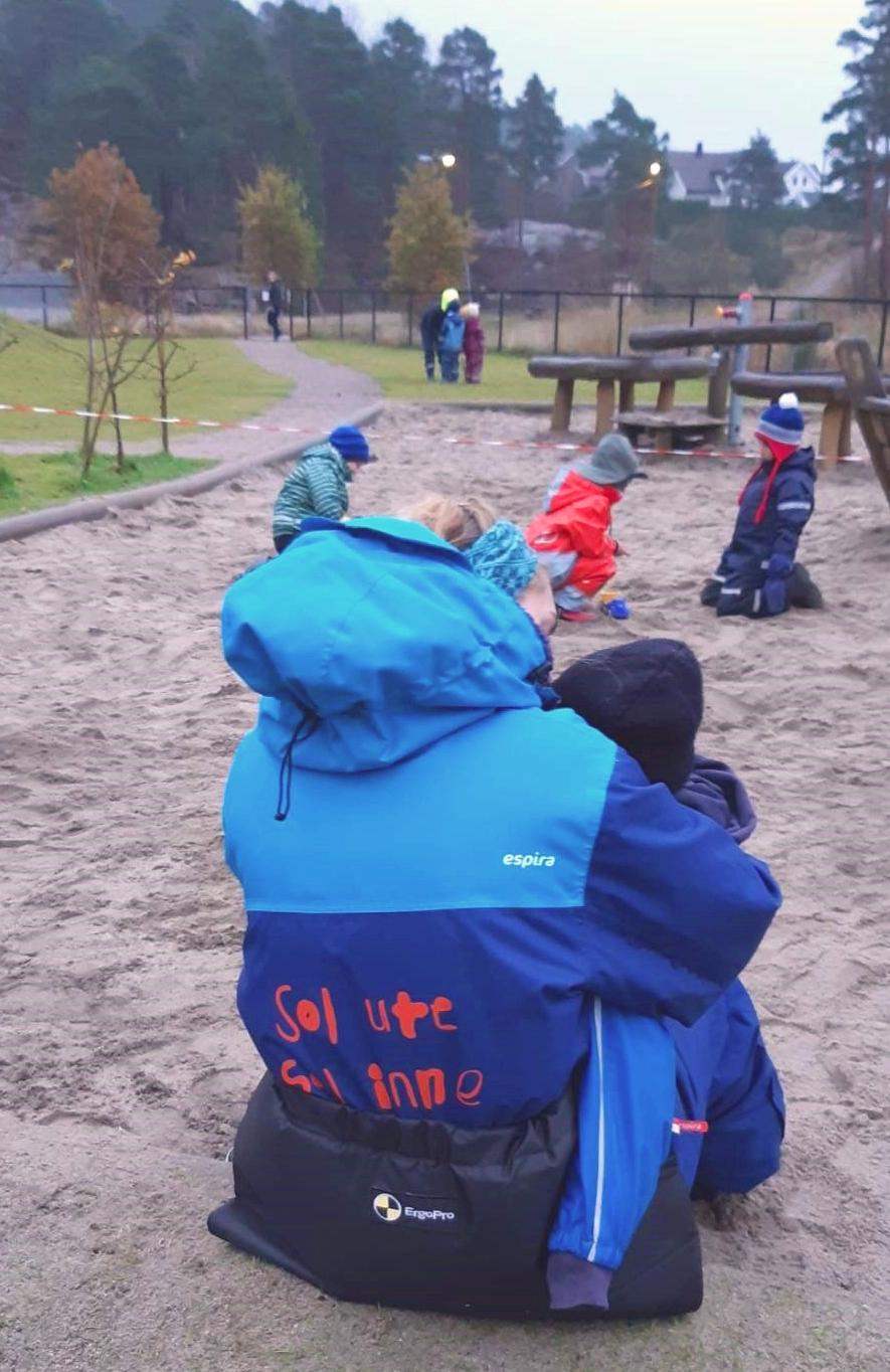 Barn og voksen ute i Espira Vedderheia barnehage, i en varm og omsorgsfull situasjon