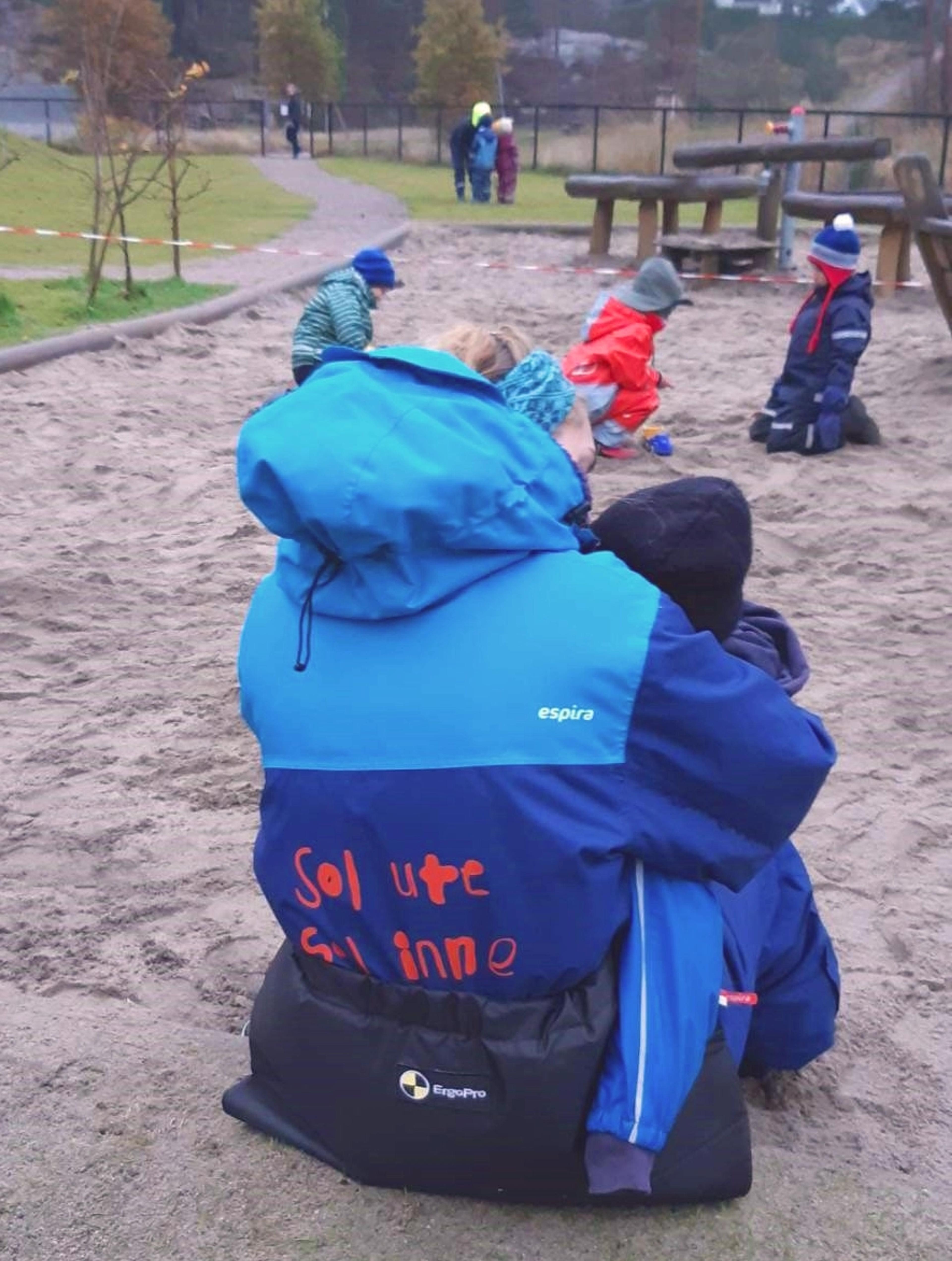 Barn og voksen ute i Espira Vedderheia barnehage, i en varm og omsorgsfull situasjon