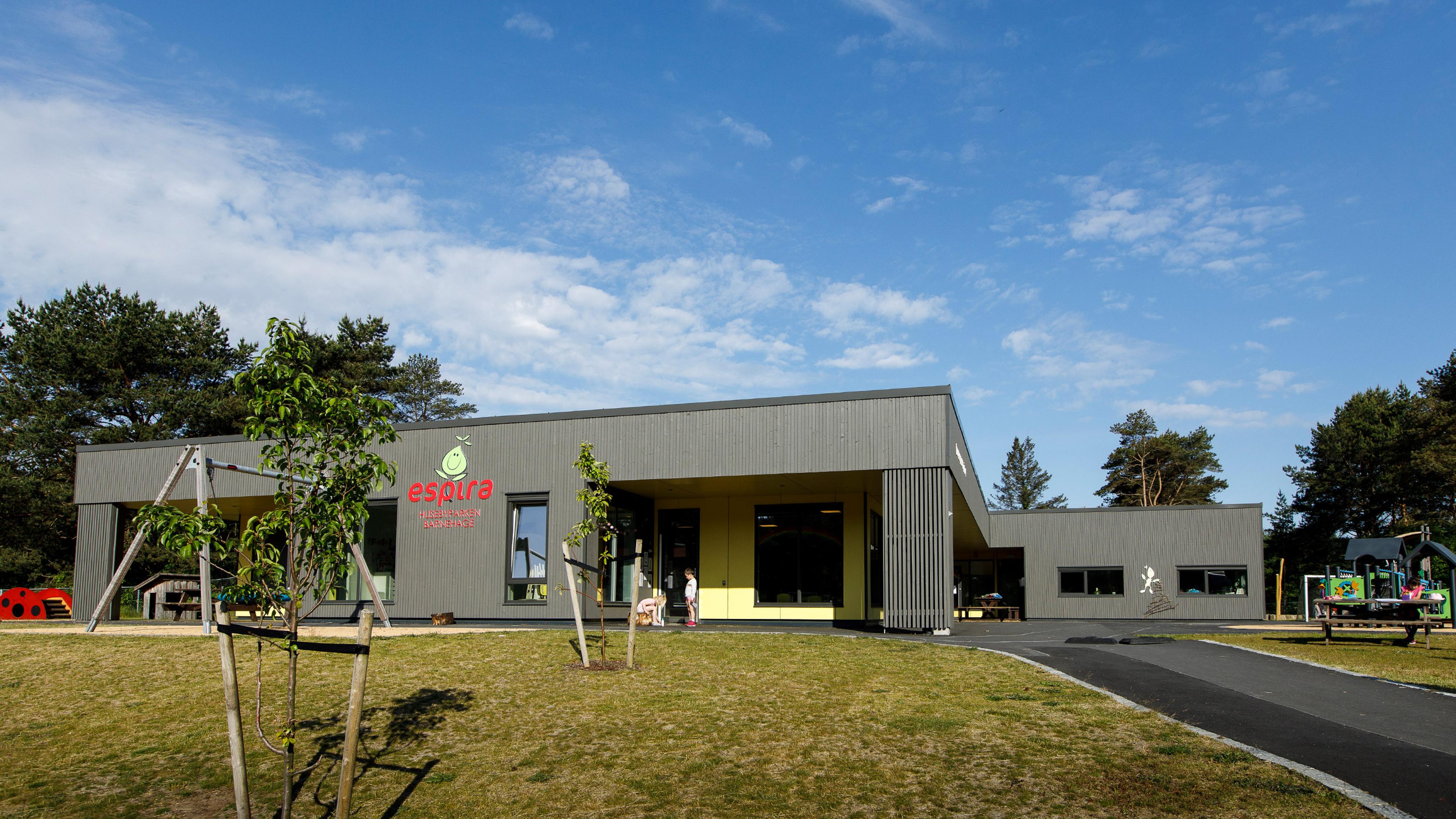 Uteområdet til Espira Husebyparken i Farsund barnehage – grått bygg med uteområde