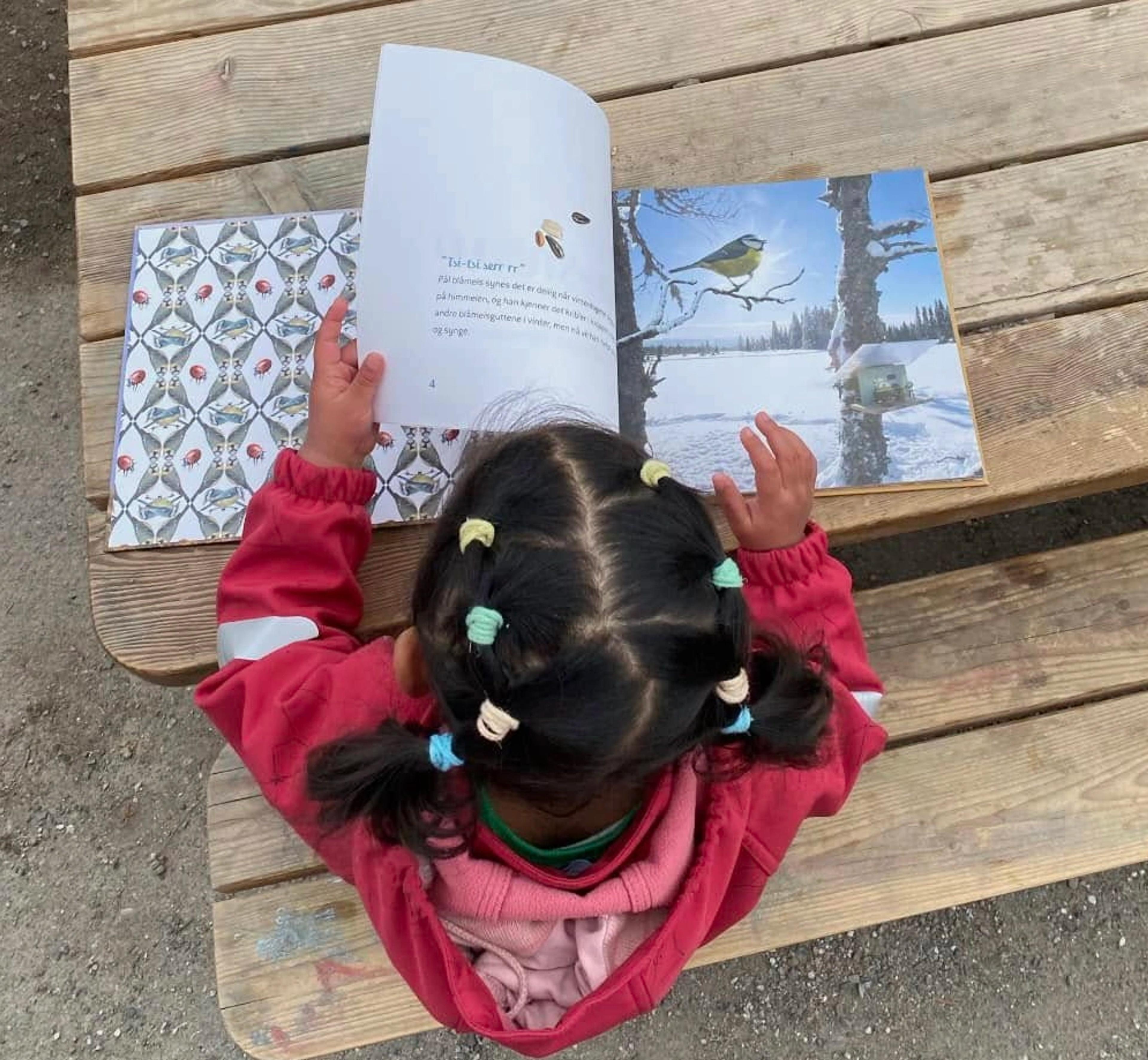 Barn som leser bok ute i Espira Snurrefjellet