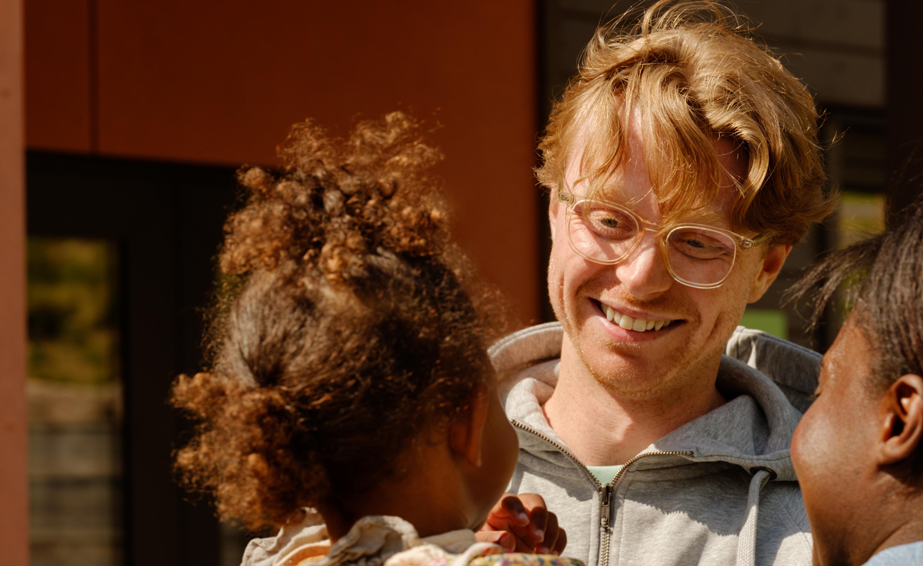 a man wearing a sweatshirt that says esprit is holding a little girl
