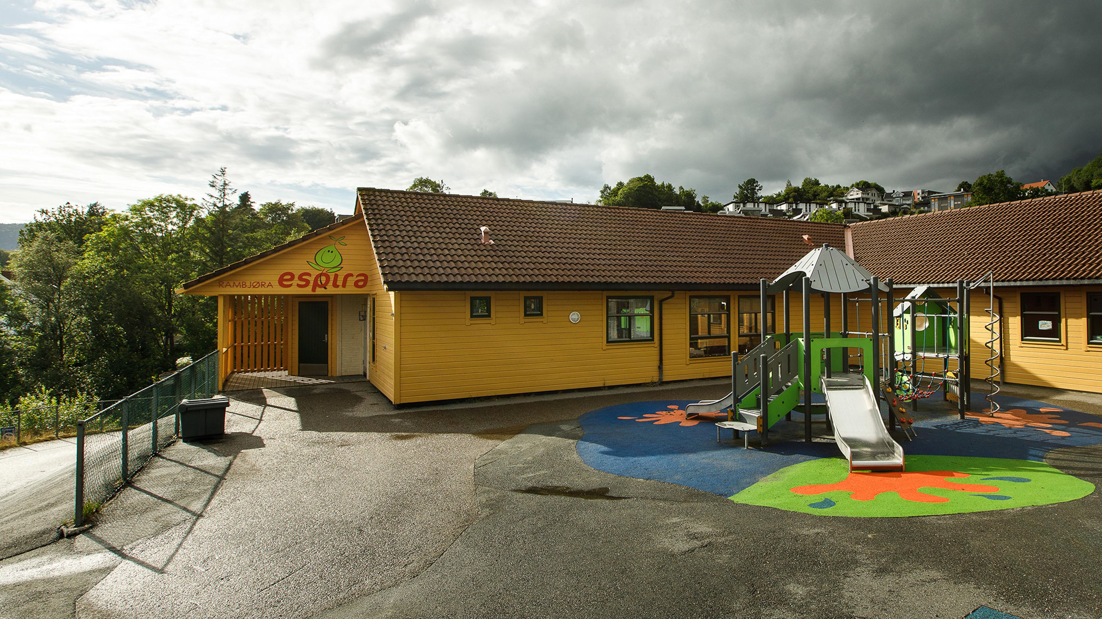 Espira Rambjøras fasade og uteområde med klatrestativ.