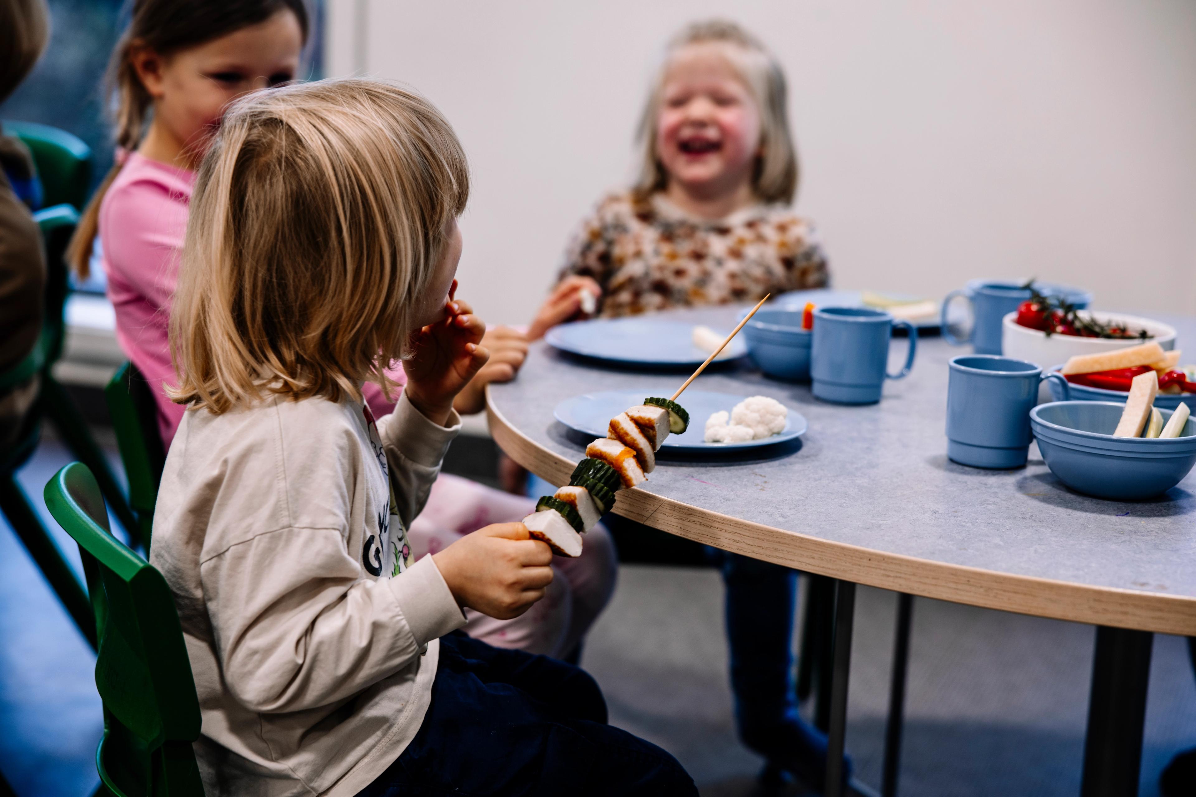 Barnehagebarn som har et sosialt måltid sammen i Espira barnehage. 