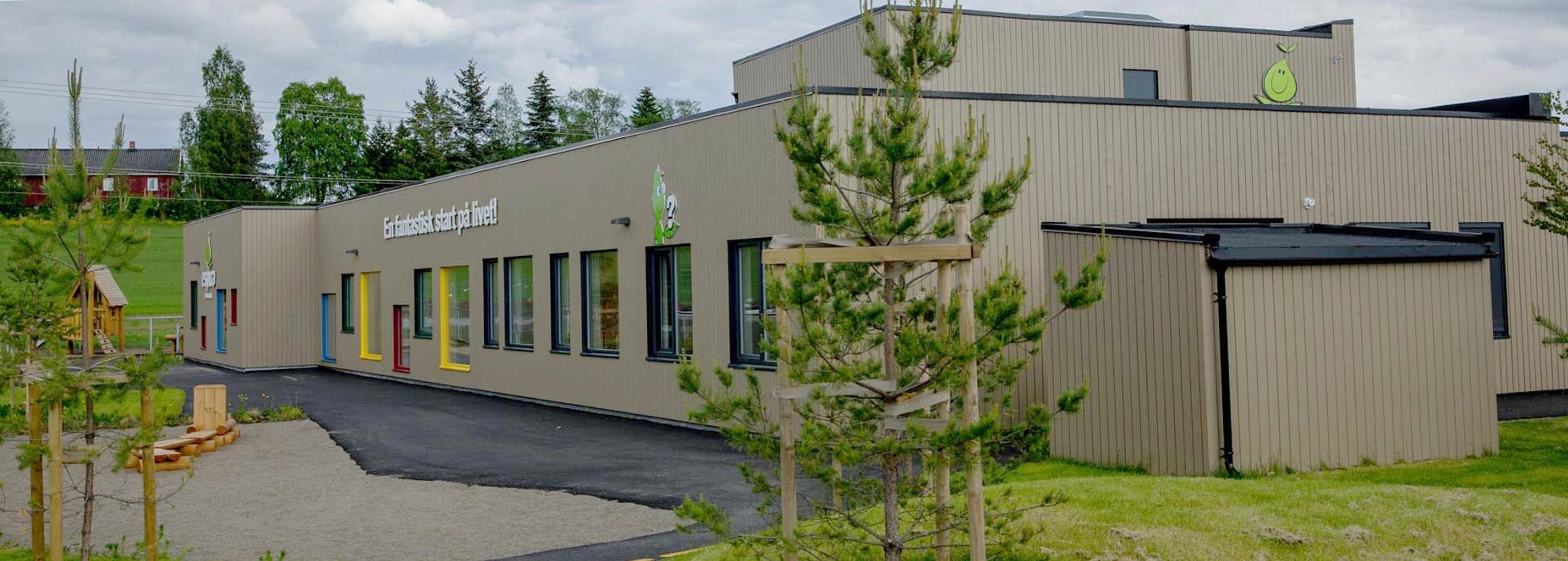 a large building with a lot of windows is surrounded by trees and grass .