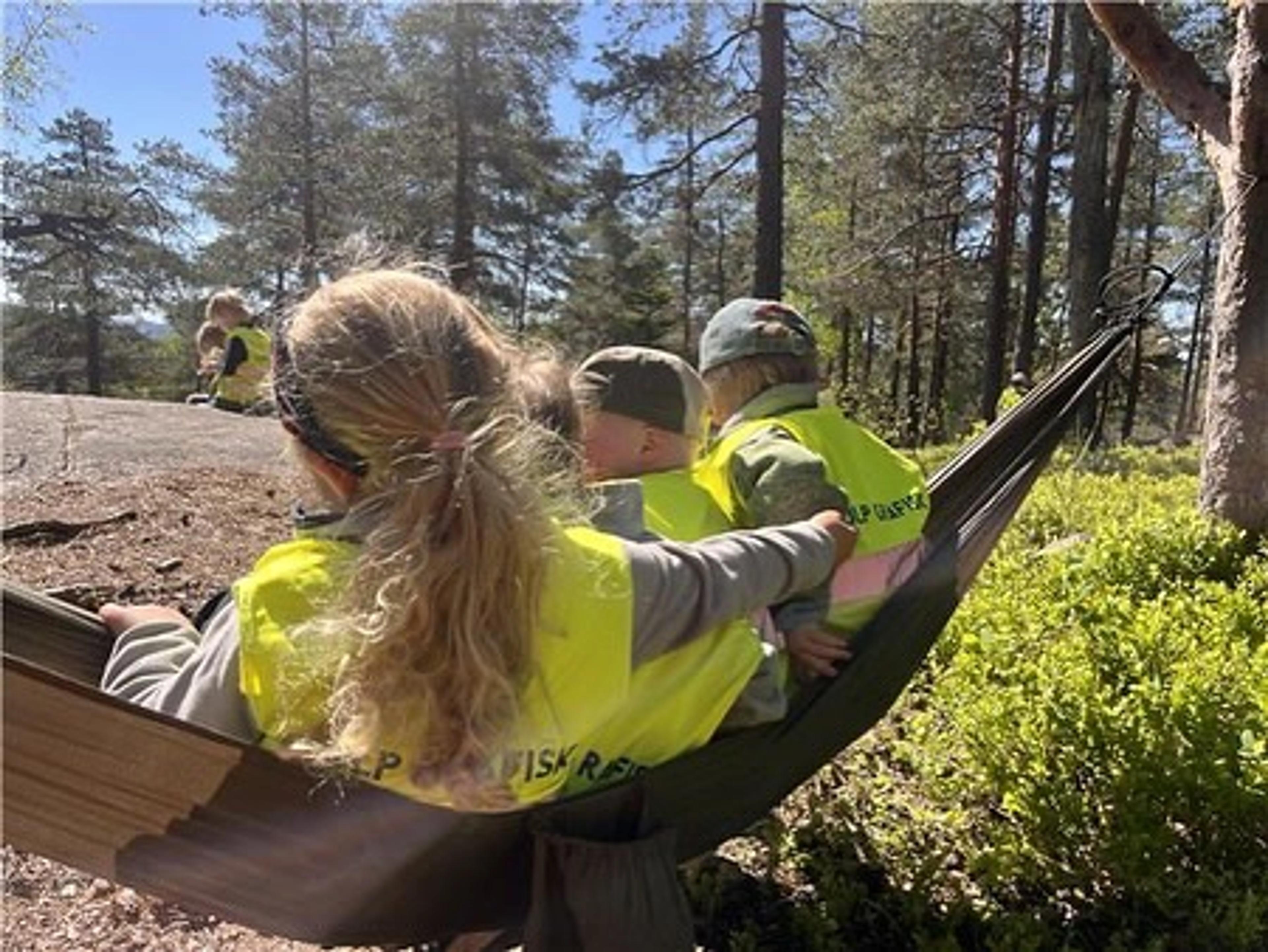 Barn og ansatt i hengekøye i Espira Marienfryd