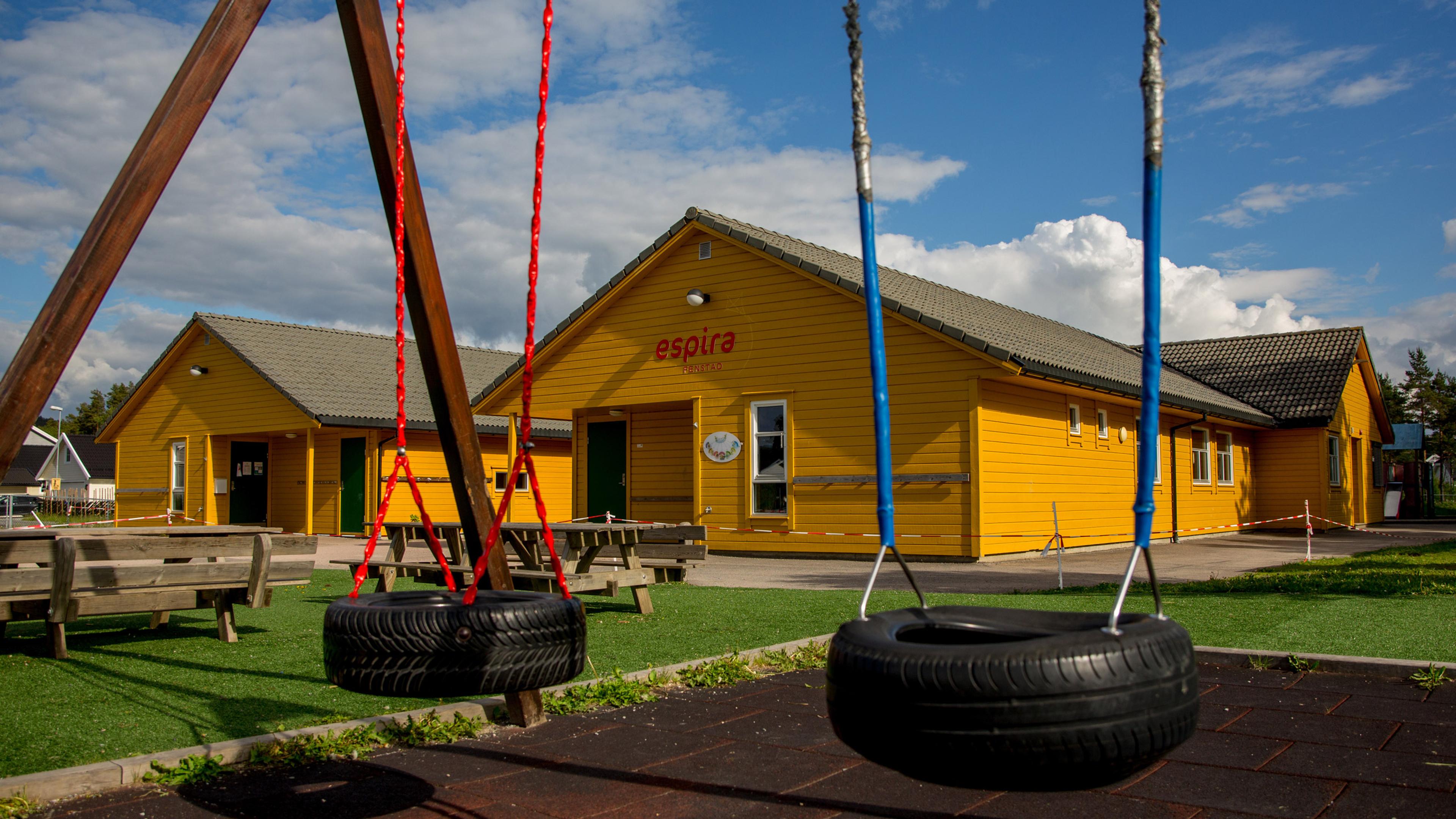 Gult barnehagebygg med husker foran i et trygt og innbydende uteområde, som legger til rette for lek, bevegelse og sosialt samspill