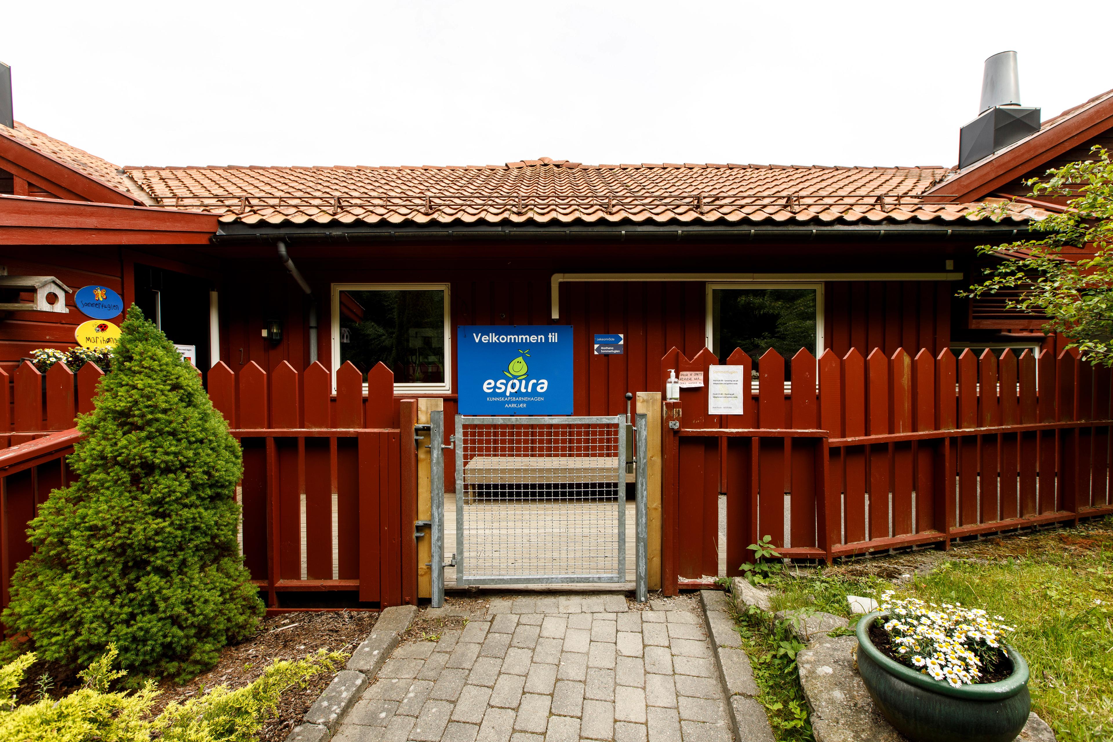 Uteområdet til Espira Aarkjær barnehage i Lindesnes Mandal – rødt bygg med port - velkommen inn