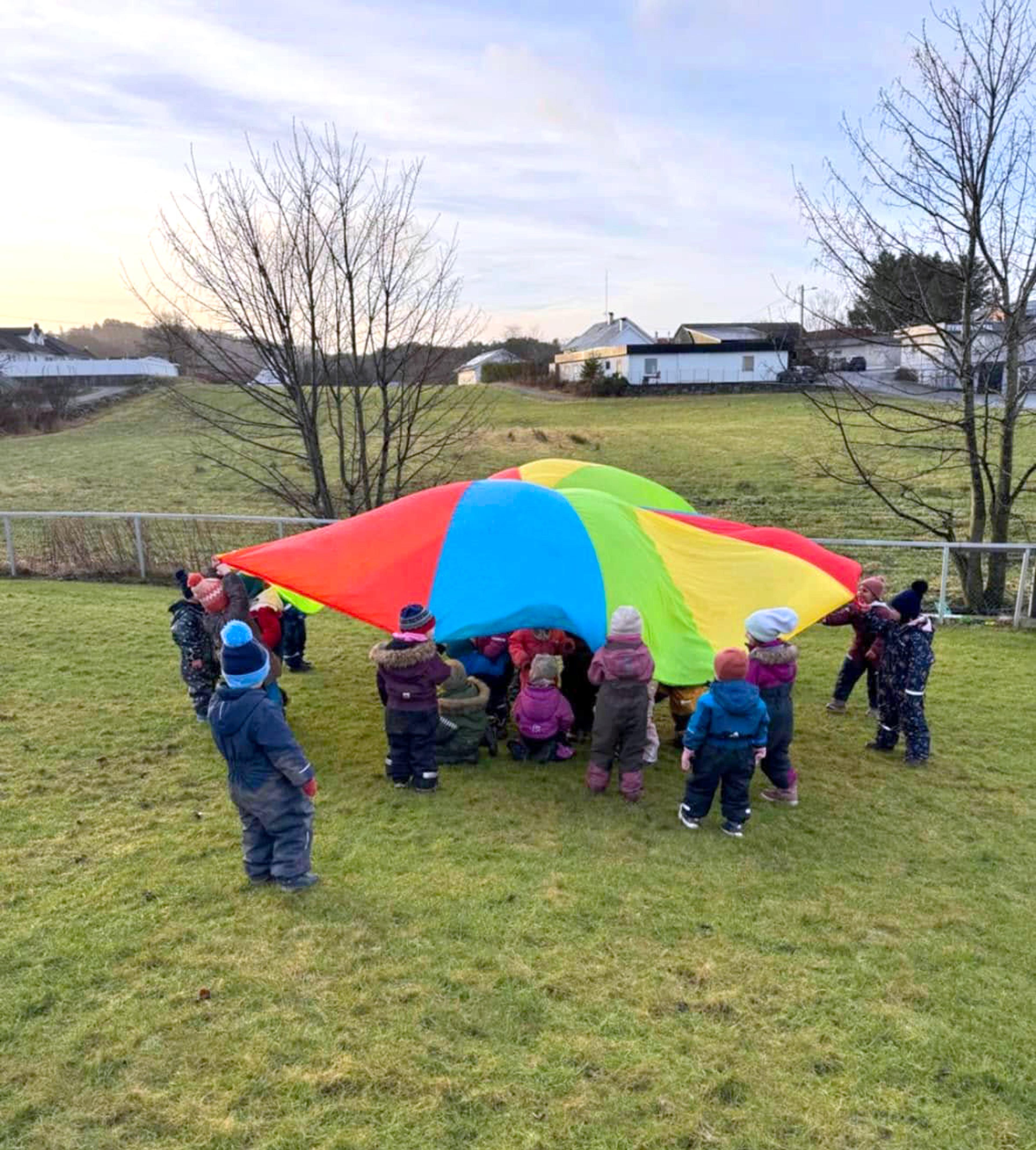 Barn leker med fallskjerm ute på Espira Karmsund