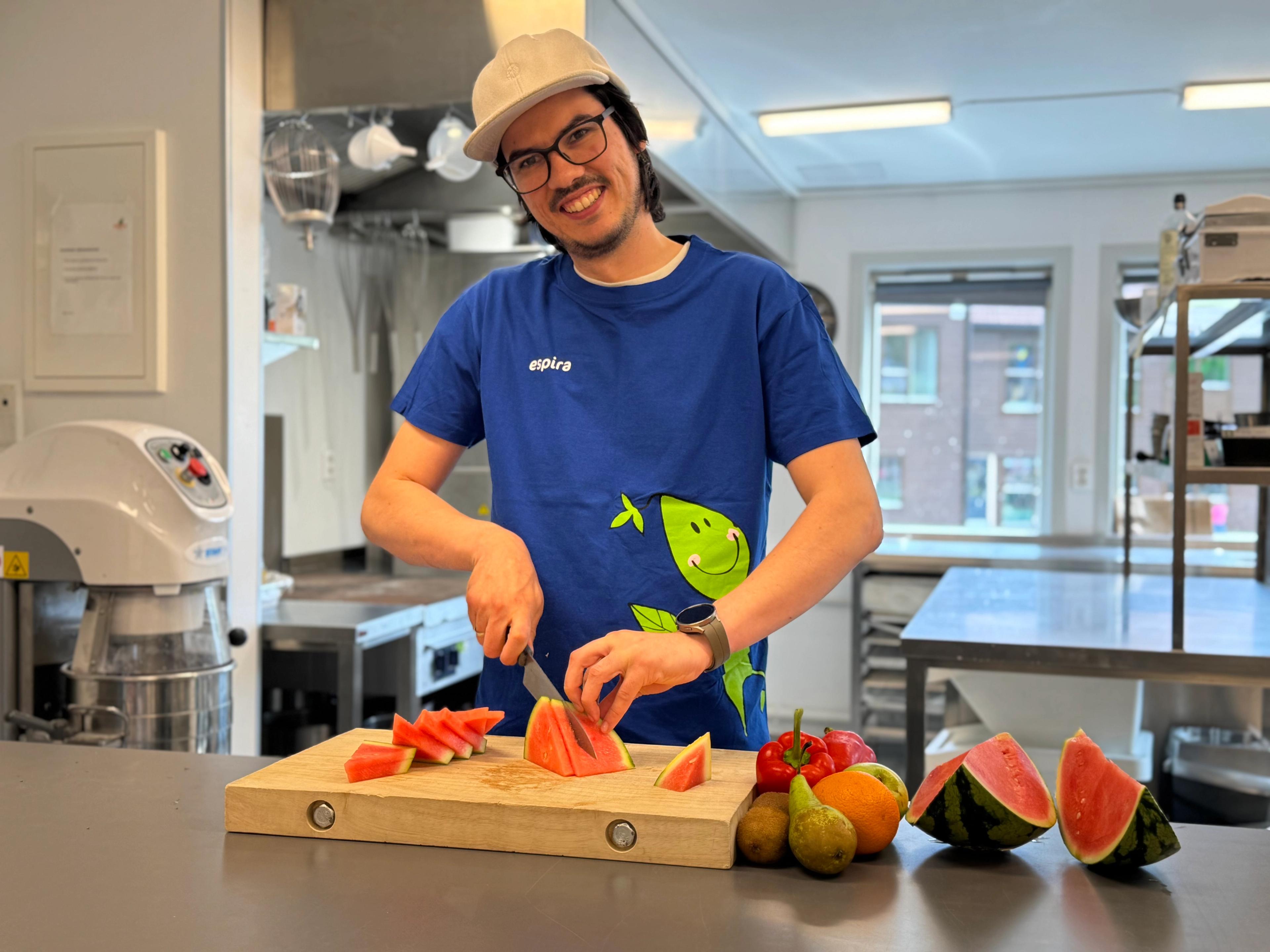 Kokken Martin skjærer opp en melon på kjøkkenet.