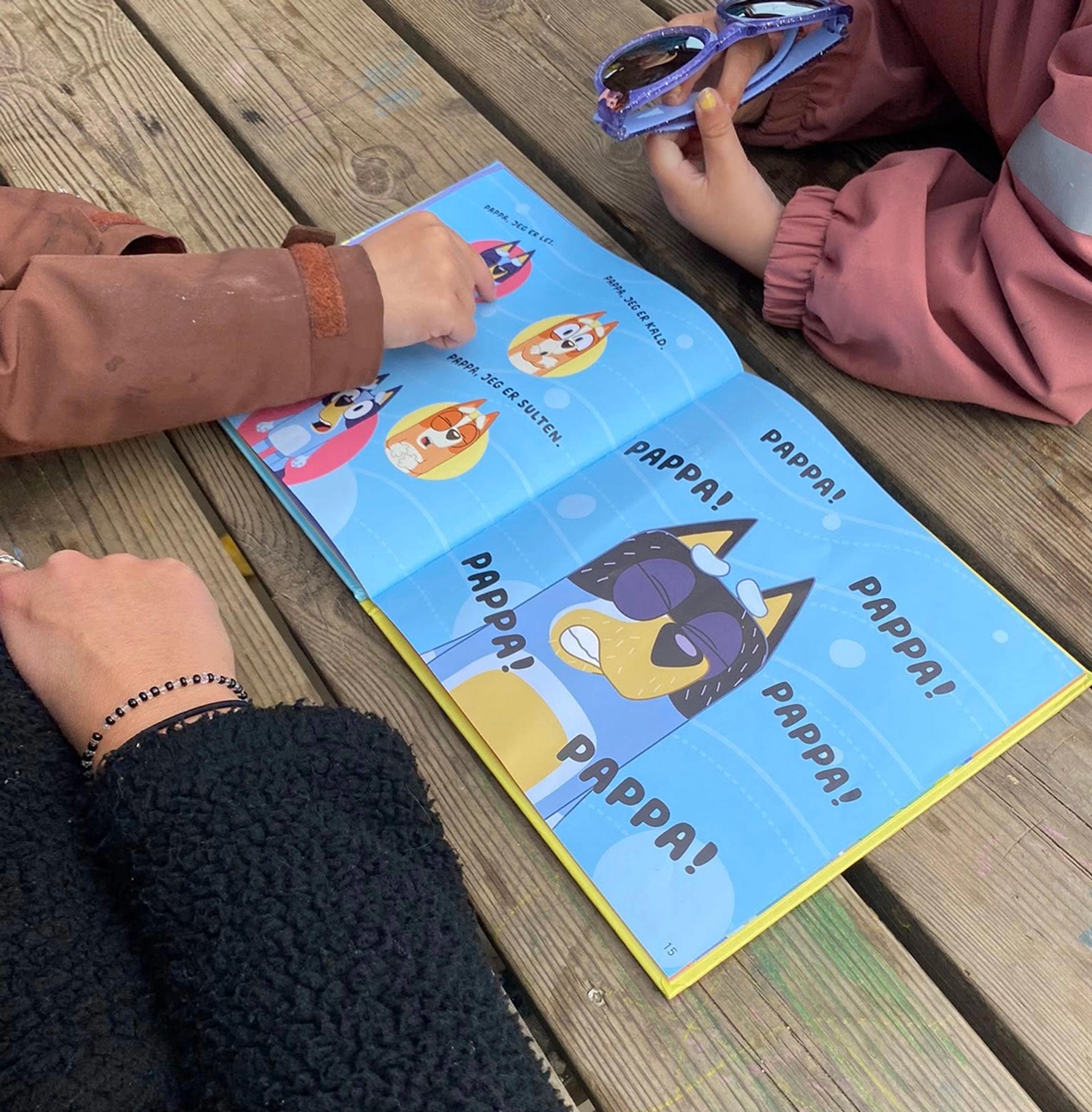 Barn som leser bok med ansatt i Espira Skjeraberget