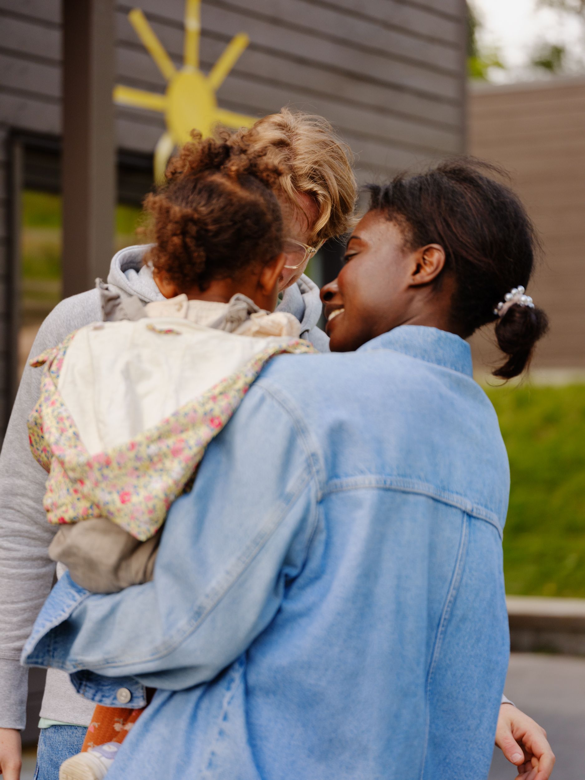 a woman is holding a little girl in her arms .