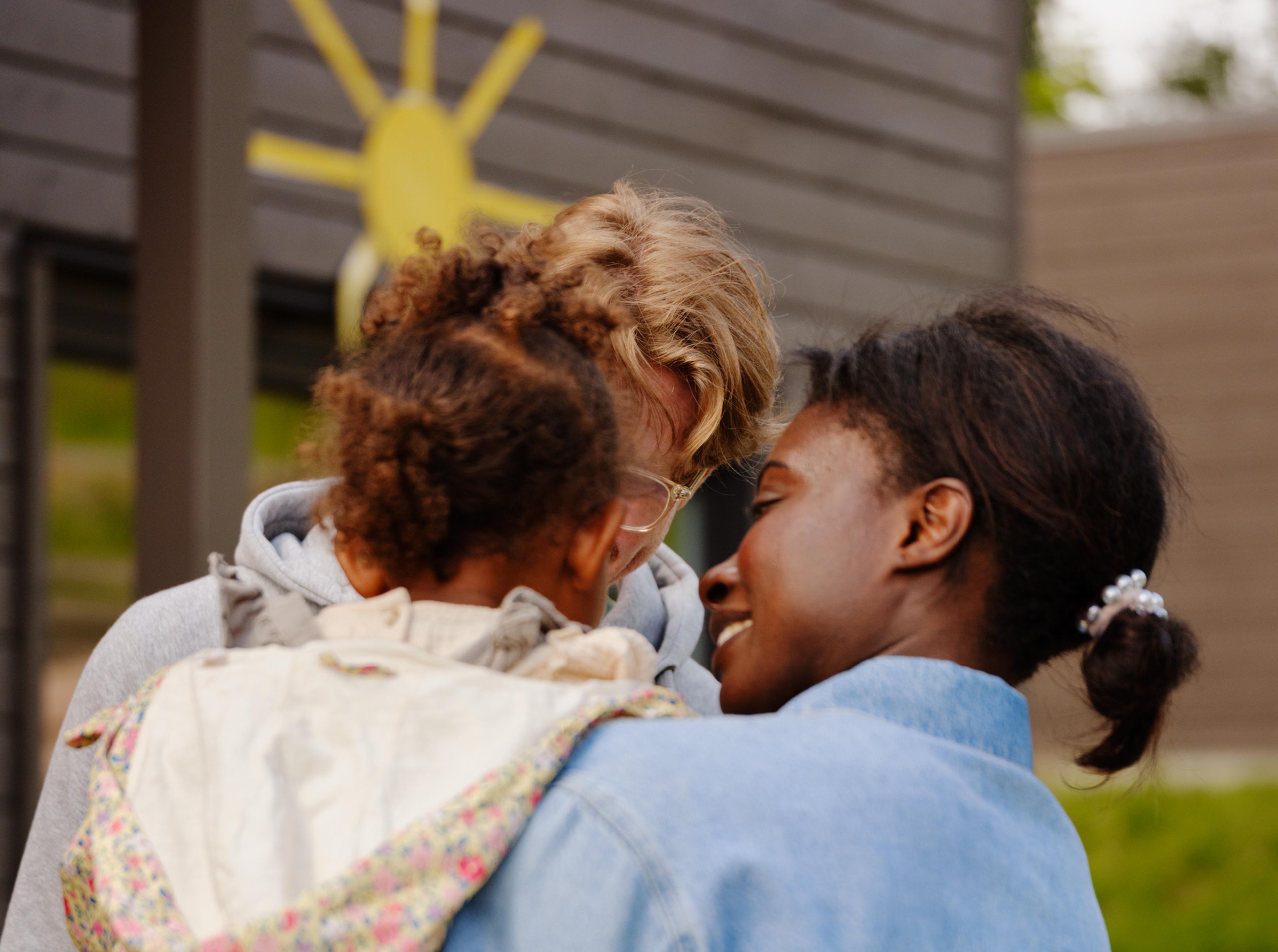 a woman is holding a little girl in her arms .