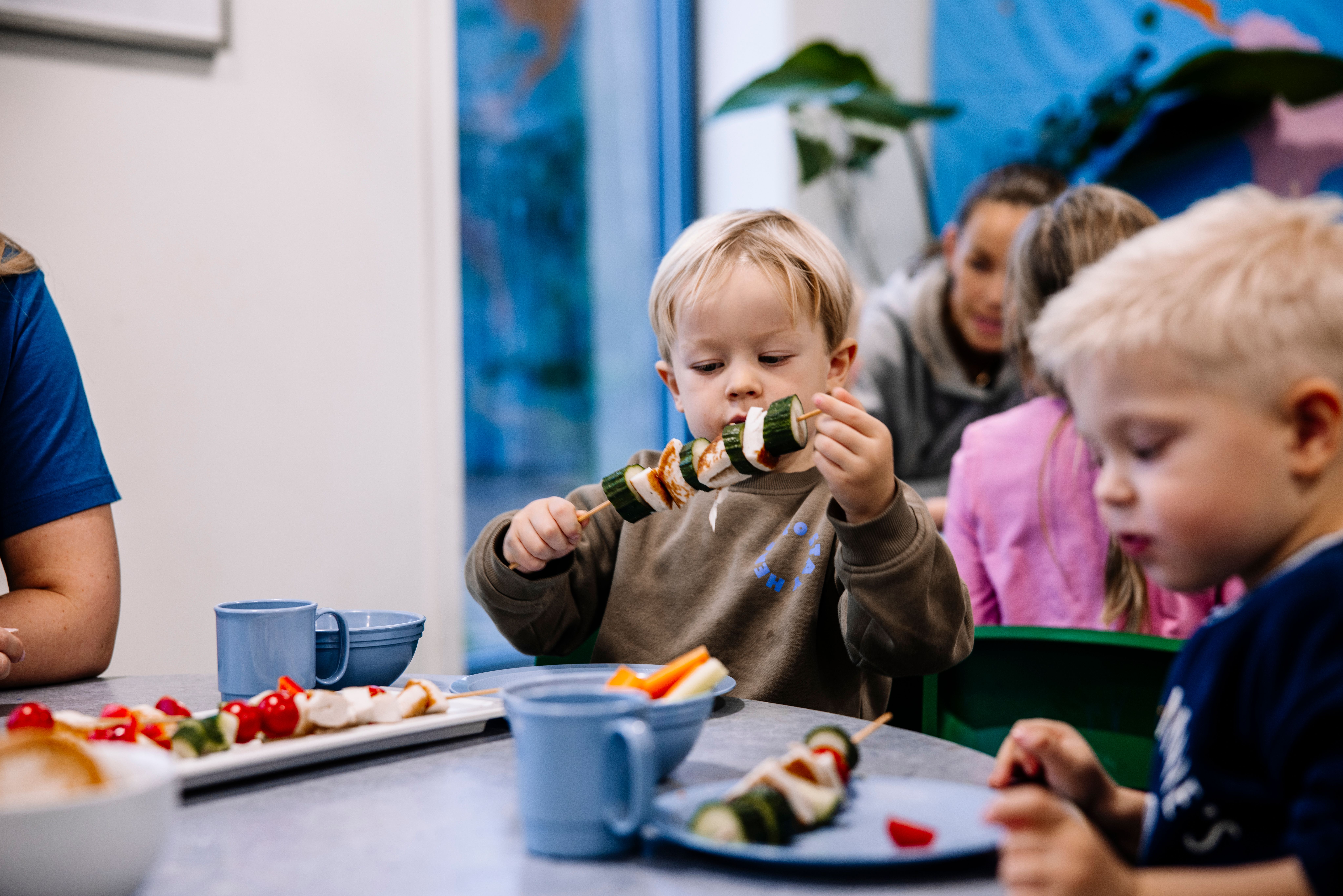 Gutt i barnehagen som spiser fisk og grønnsaker sammen med andre barn. Espira er en matpakkefri barnehage. 