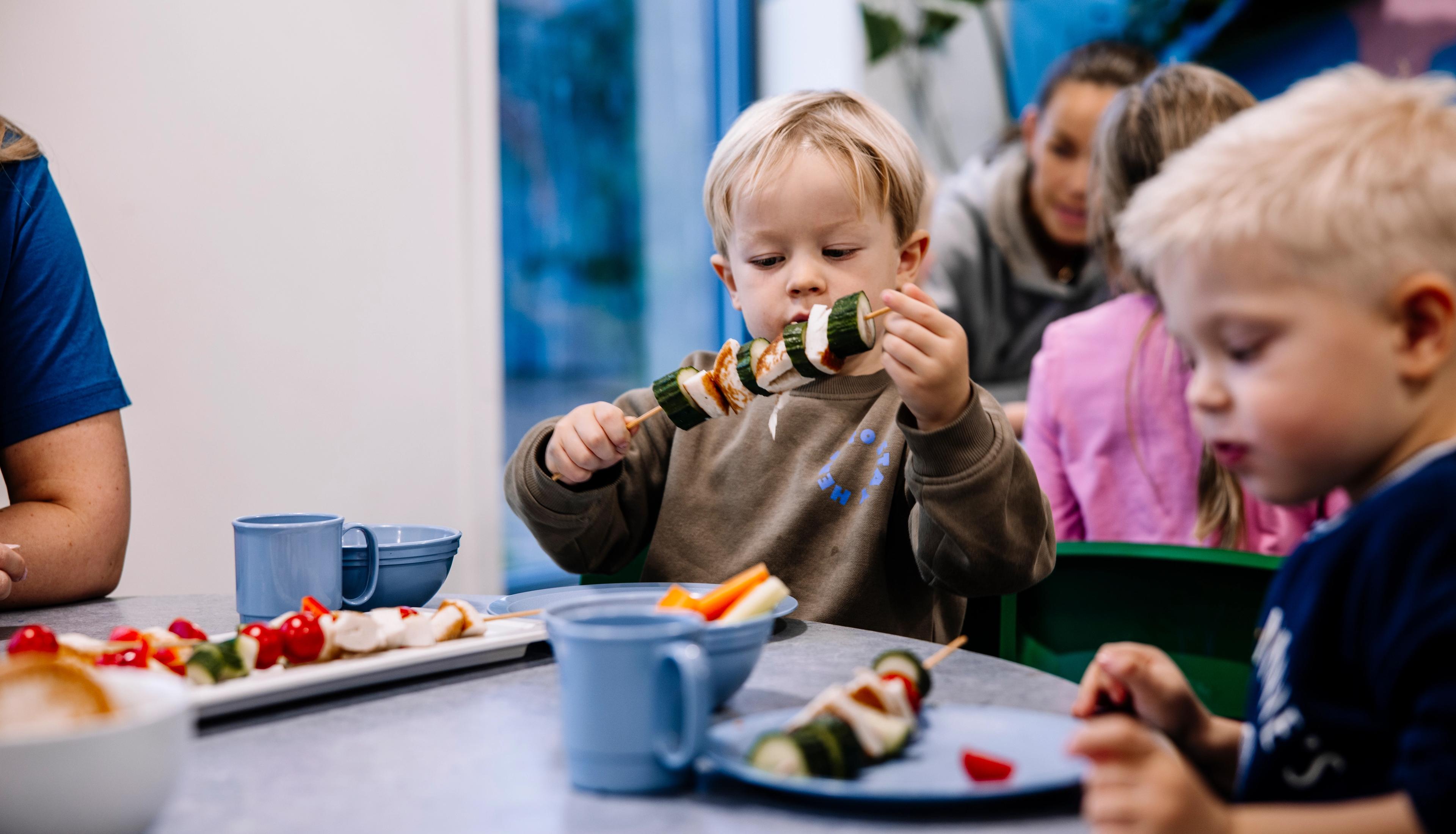 Gutt i barnehagen som spiser fisk og grønnsaker sammen med andre barn. Espira er en matpakkefri barnehage.