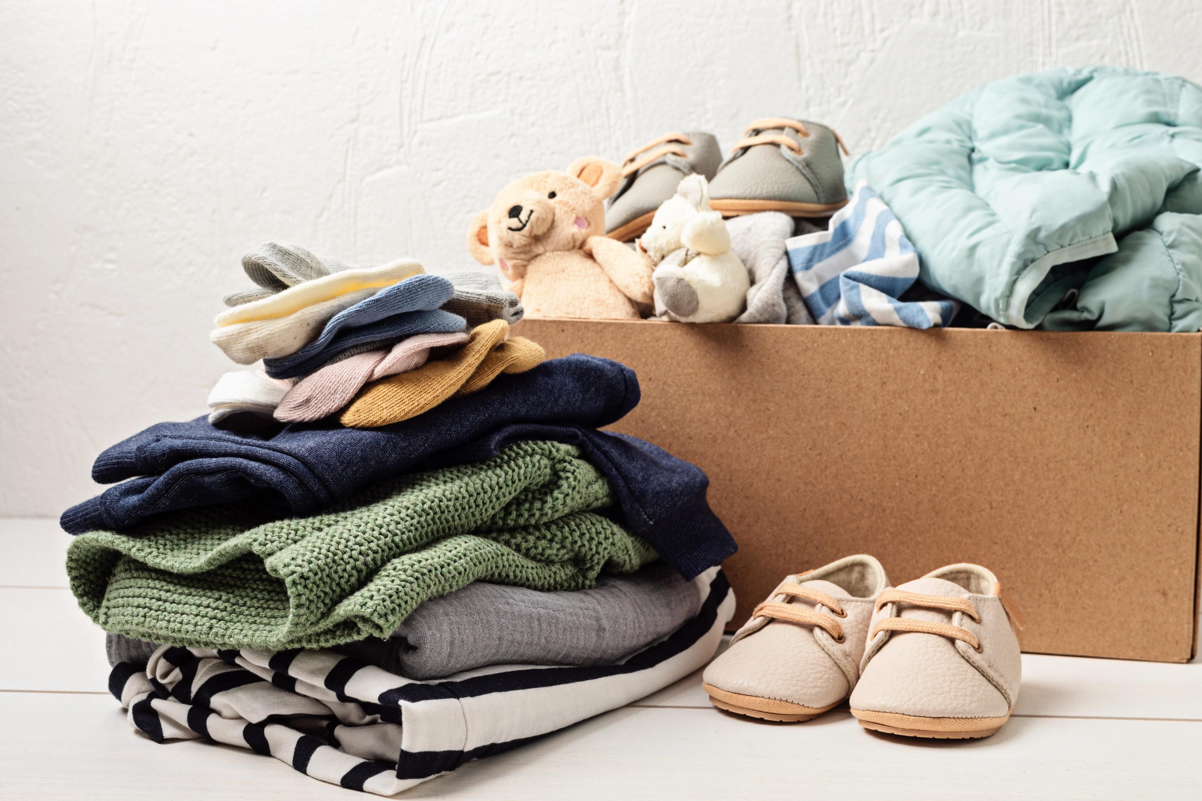 a box filled with clothes , shoes , and a teddy bear .