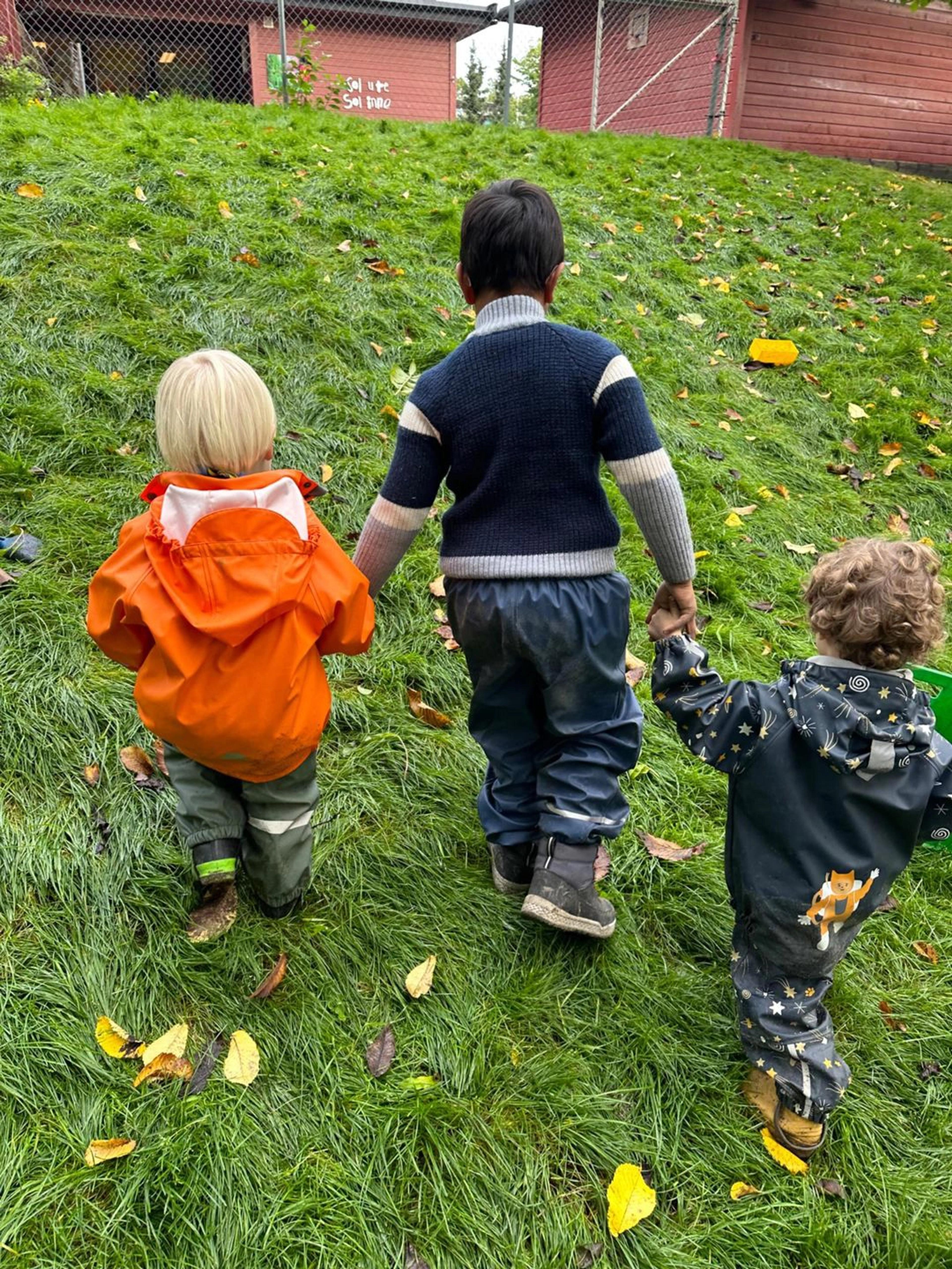 Barnehagebarn som holder hverandre i hendene i Espira Evje