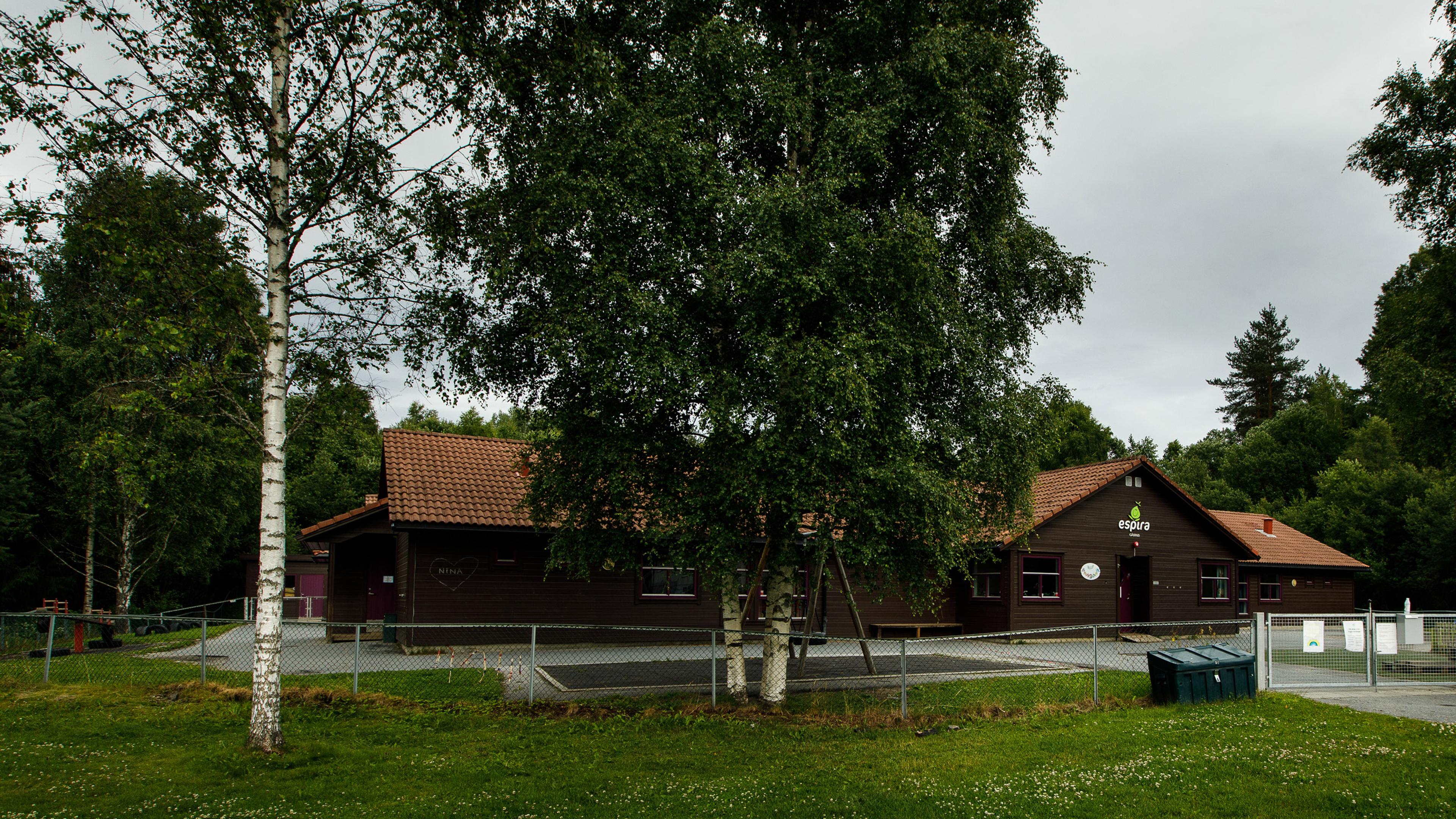 Fasade og uteområde i Espira Gåserud - Brunt bygg med lekeområde