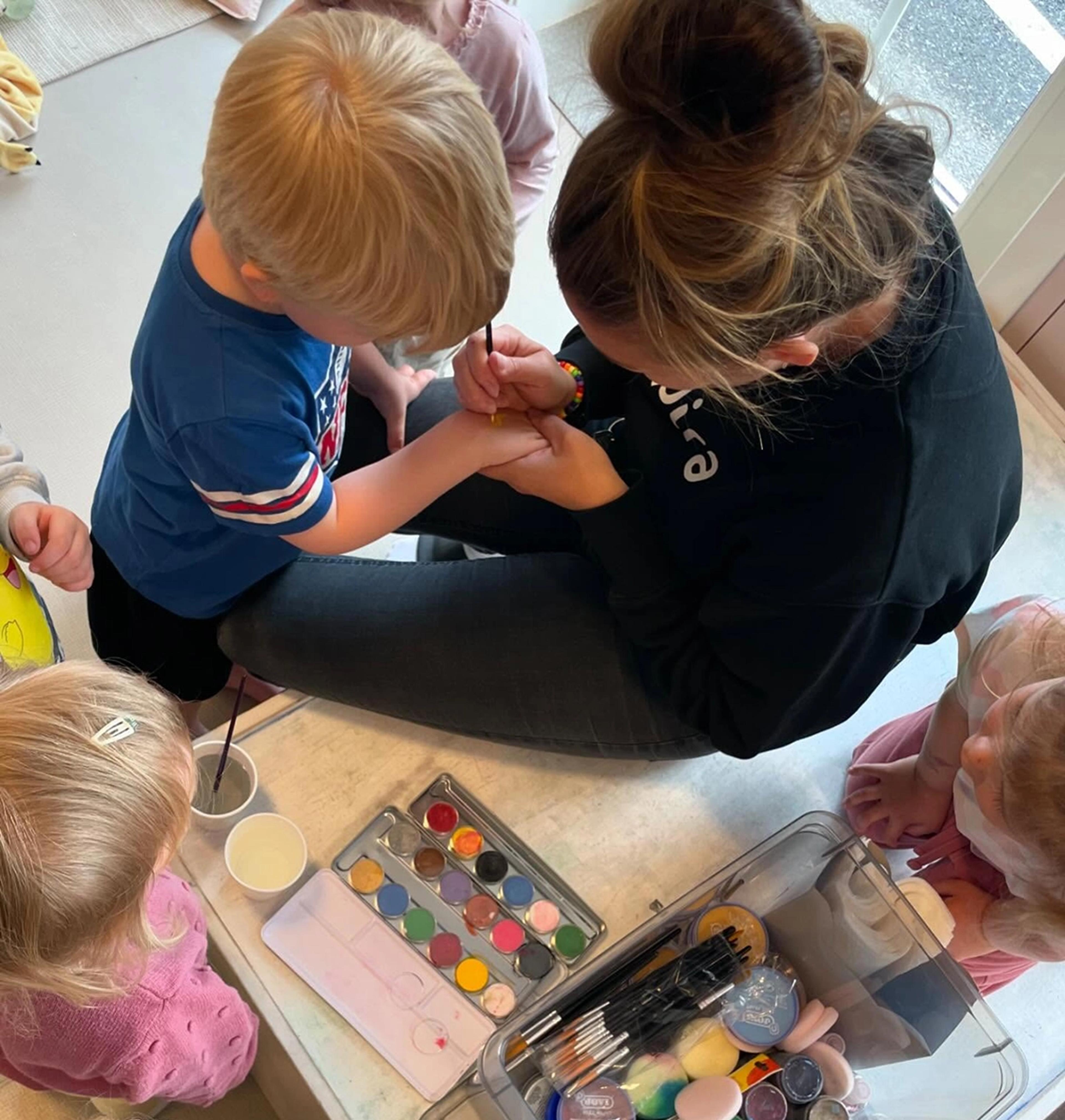 Barn som leker sammen med ansatt i Espira Oreid