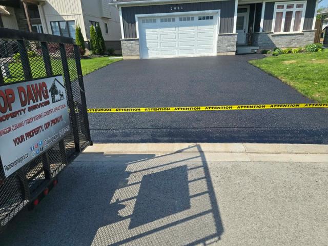 Freshly sealed asphalt driveway with caution tape, St. Catharines