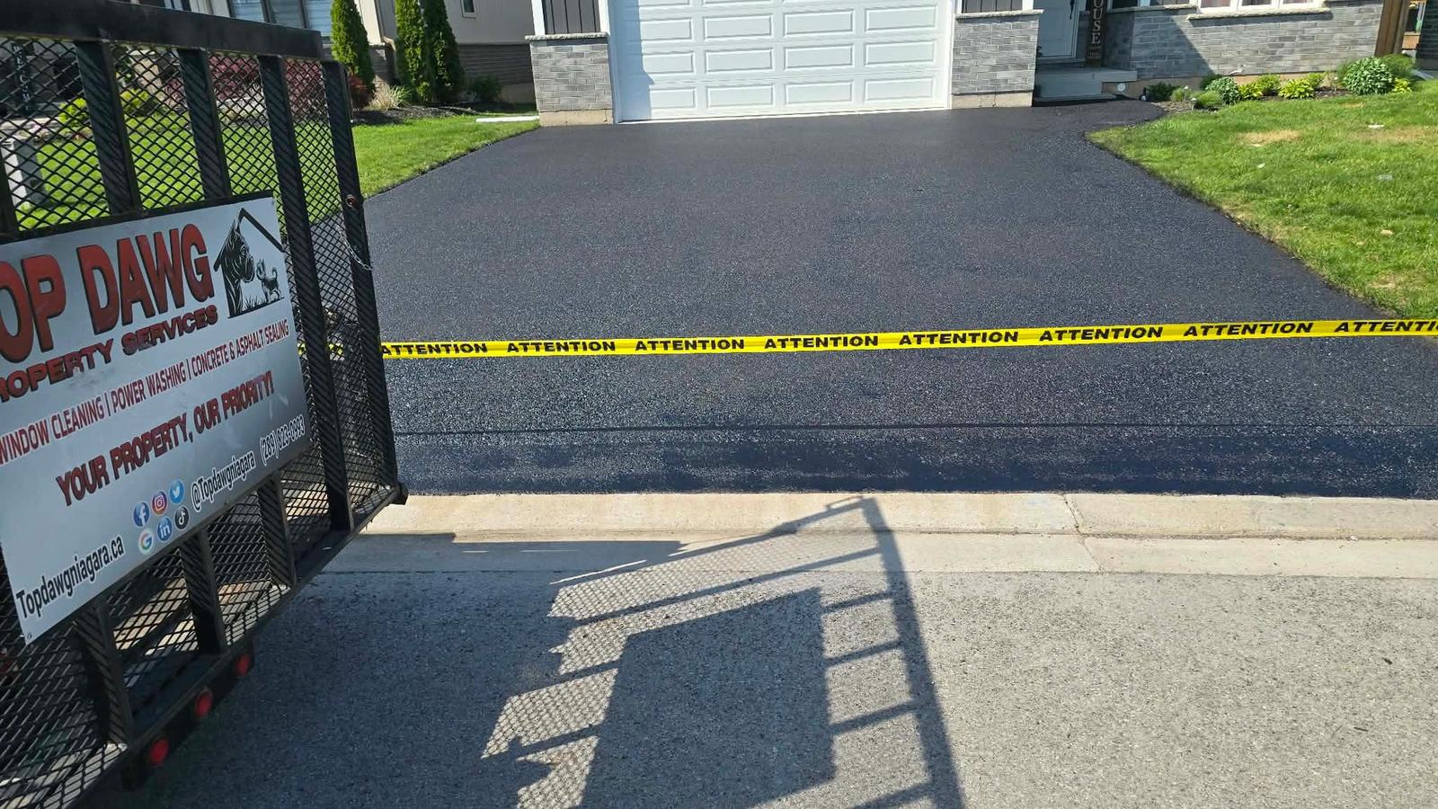 Freshly sealed asphalt driveway with caution tape, St. Catharines
