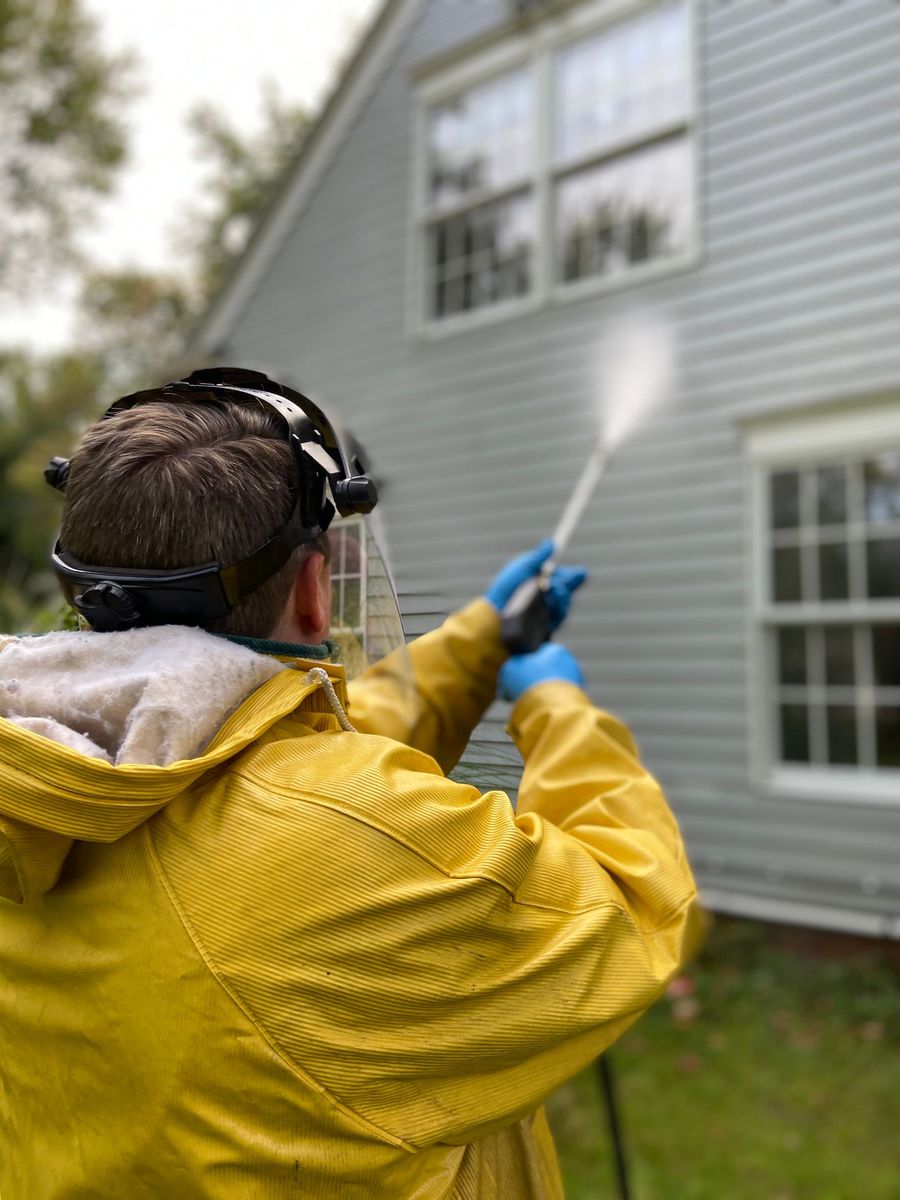 Top Dawg Property Services technician pressure washing home siding