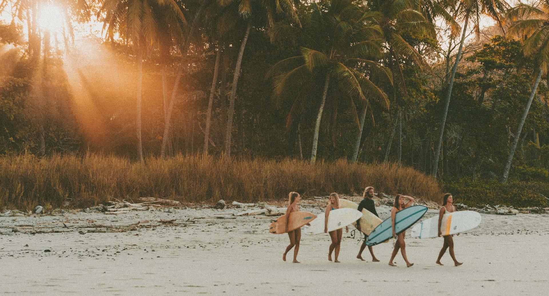 Friends going to surf at sunset in Sri Lanka