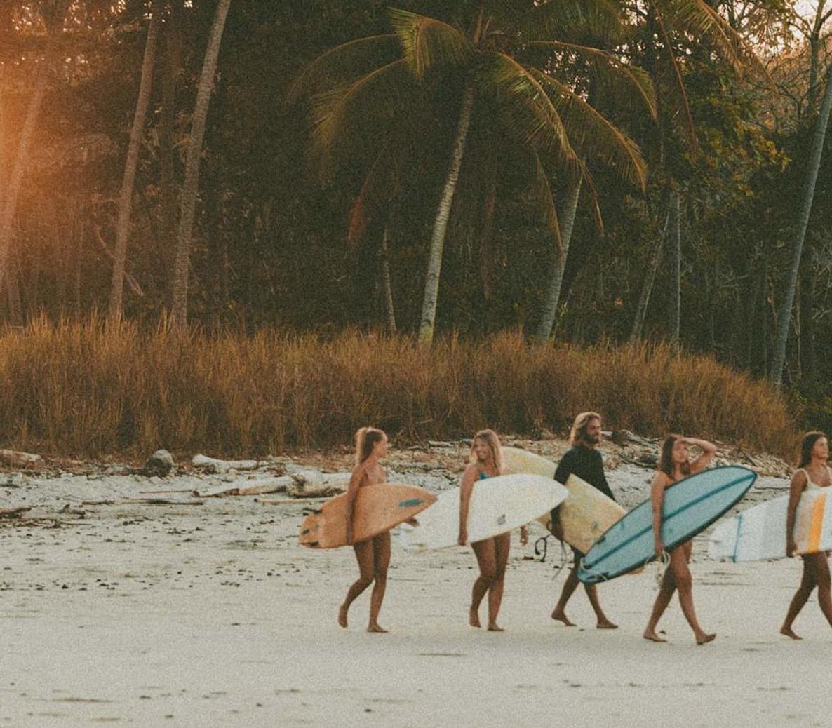 Friends going to surf at sunset in Sri Lanka