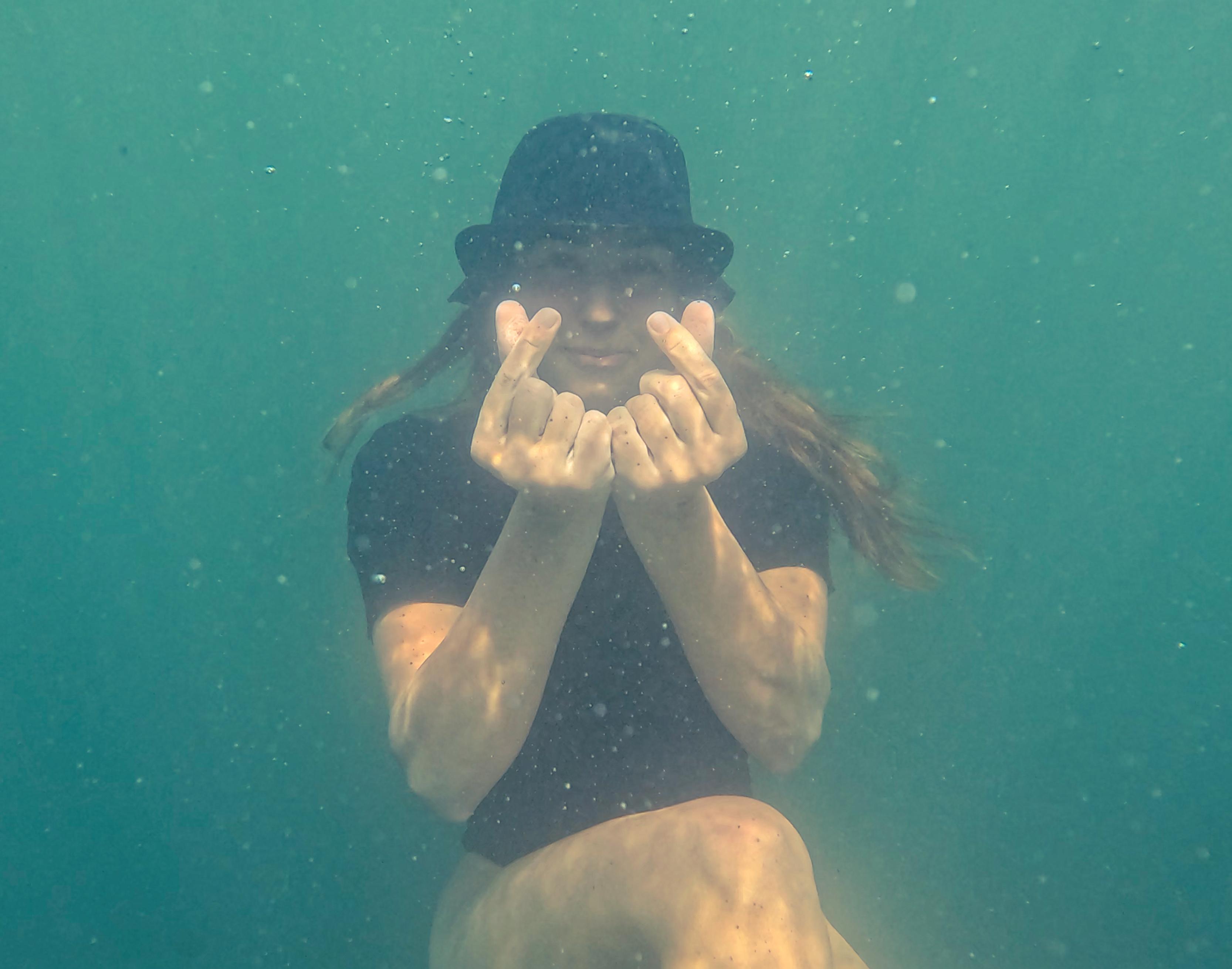 Underwater portrait of Diana making a heart shape with her hands