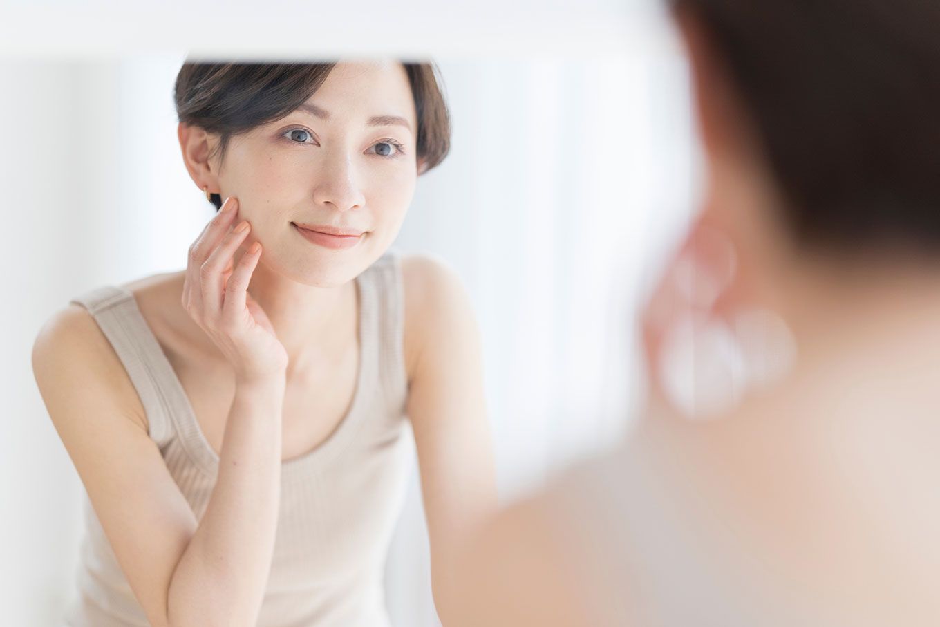 女性が鏡を見て微笑んでいる