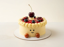 Jellycat-inspired cream cake with a smiley face and little feet, topped with berry glaze, blueberries and a cherry
