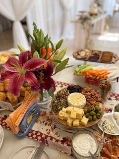 Grazing table scene with pink lilies and a cheese board