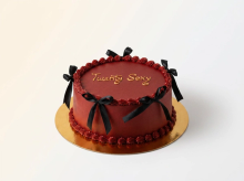 Deep red ribbon cake with sculpted black bows and gold Twenty Sexy lettering