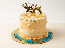 White and peach ombre buttercream cake with piped rosettes and a milestone number topper