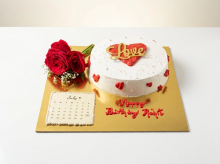 White buttercream cake with a red heart centre and gold Love topper