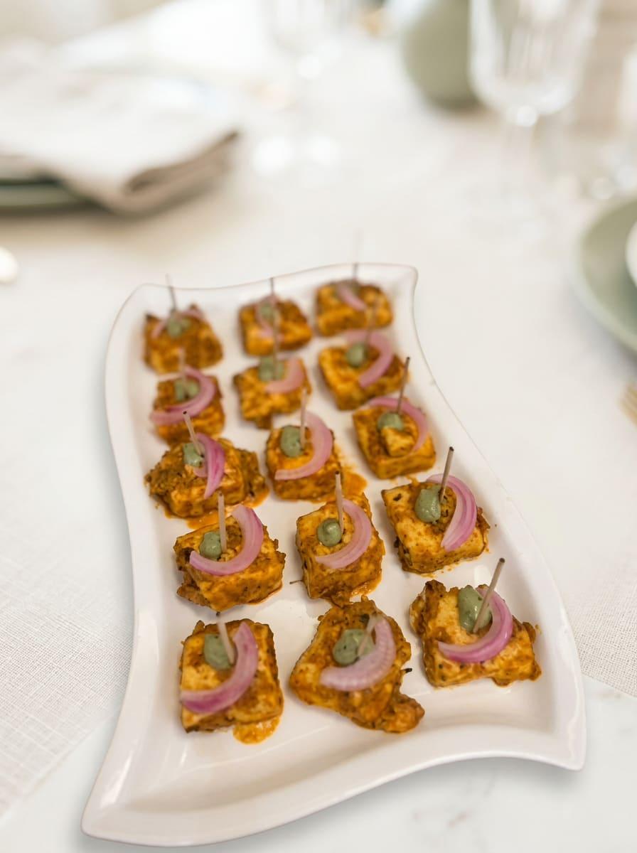 Paneer tikka squares with pickled onion and chutney on cocktail picks