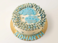 Blue and white buttercream cake covered in piped stars and pearls with Welcome Home cloud toppers