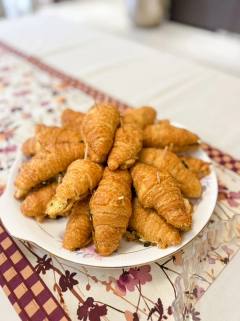 Mini stuffed croissants stacked on a floral plate