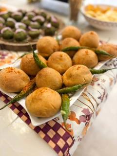 Savoury besan bites garnished with green chillies on white platters